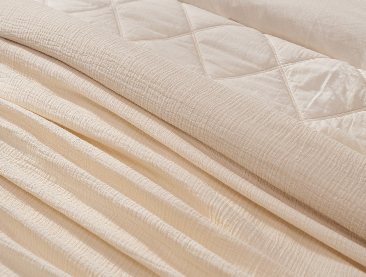 Coyuchi Topanga Organic Cotton Matelasse Throw - close up on mattress #colour_Undyed