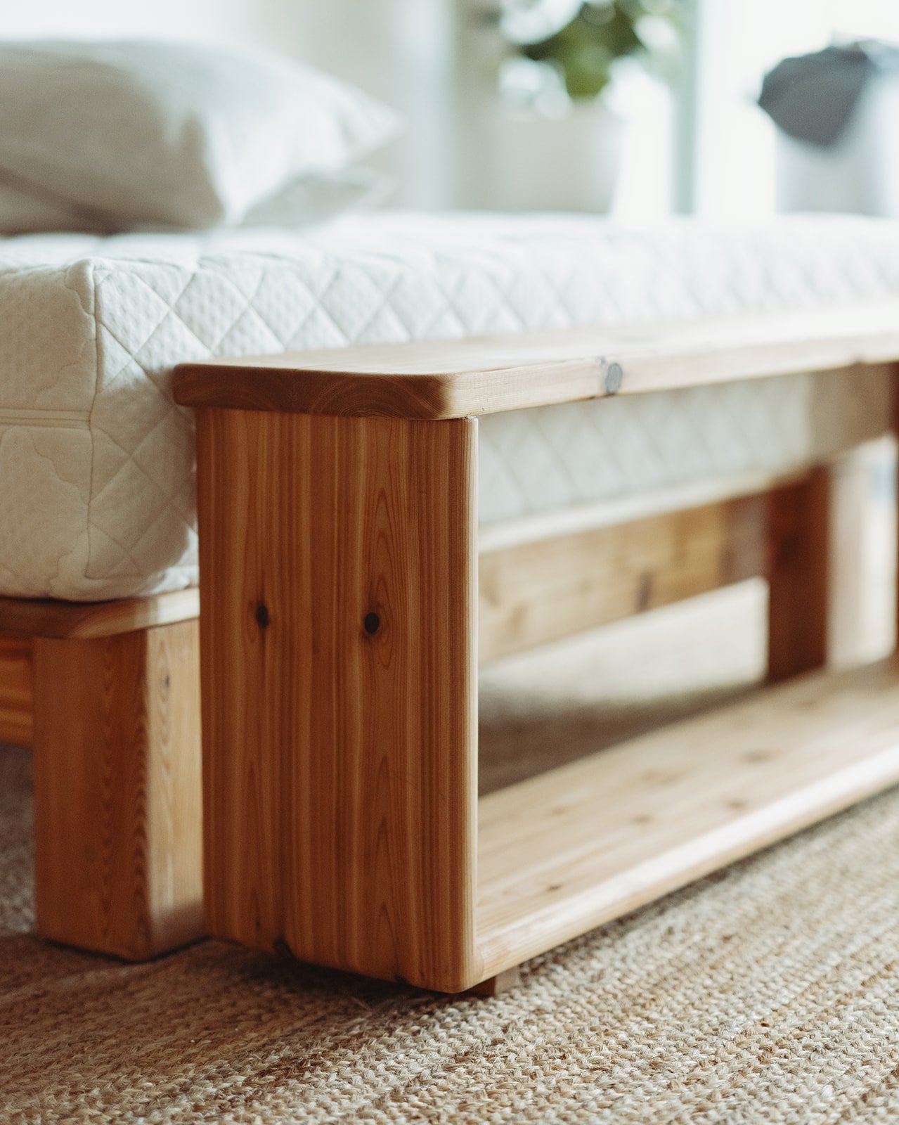Adrift Cedar Crest Bench - corner shot with natural light in front of matching bed frame