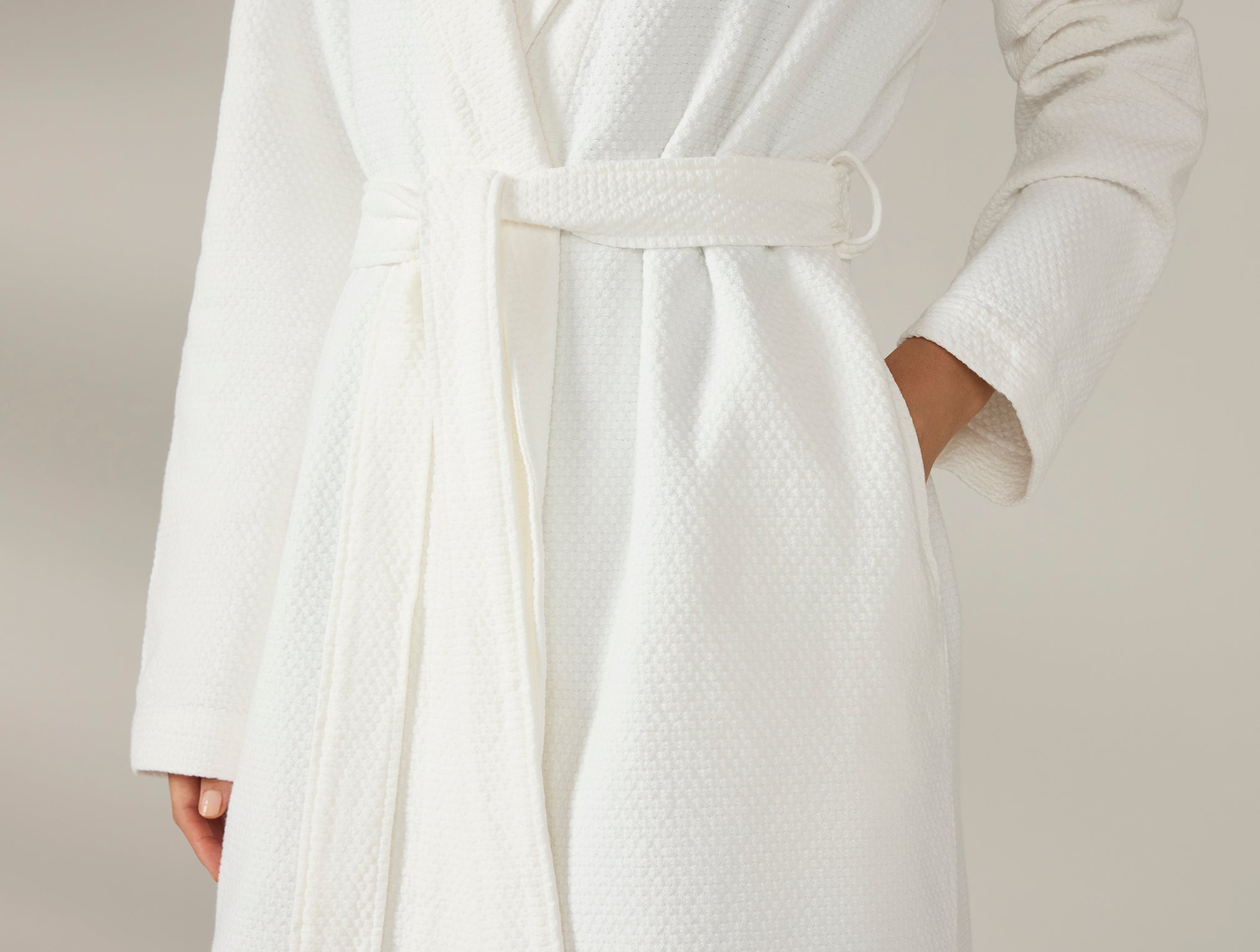 Coyuchi Adriatic Organic Robe - close up of model hand in pocket #colour_alpine white