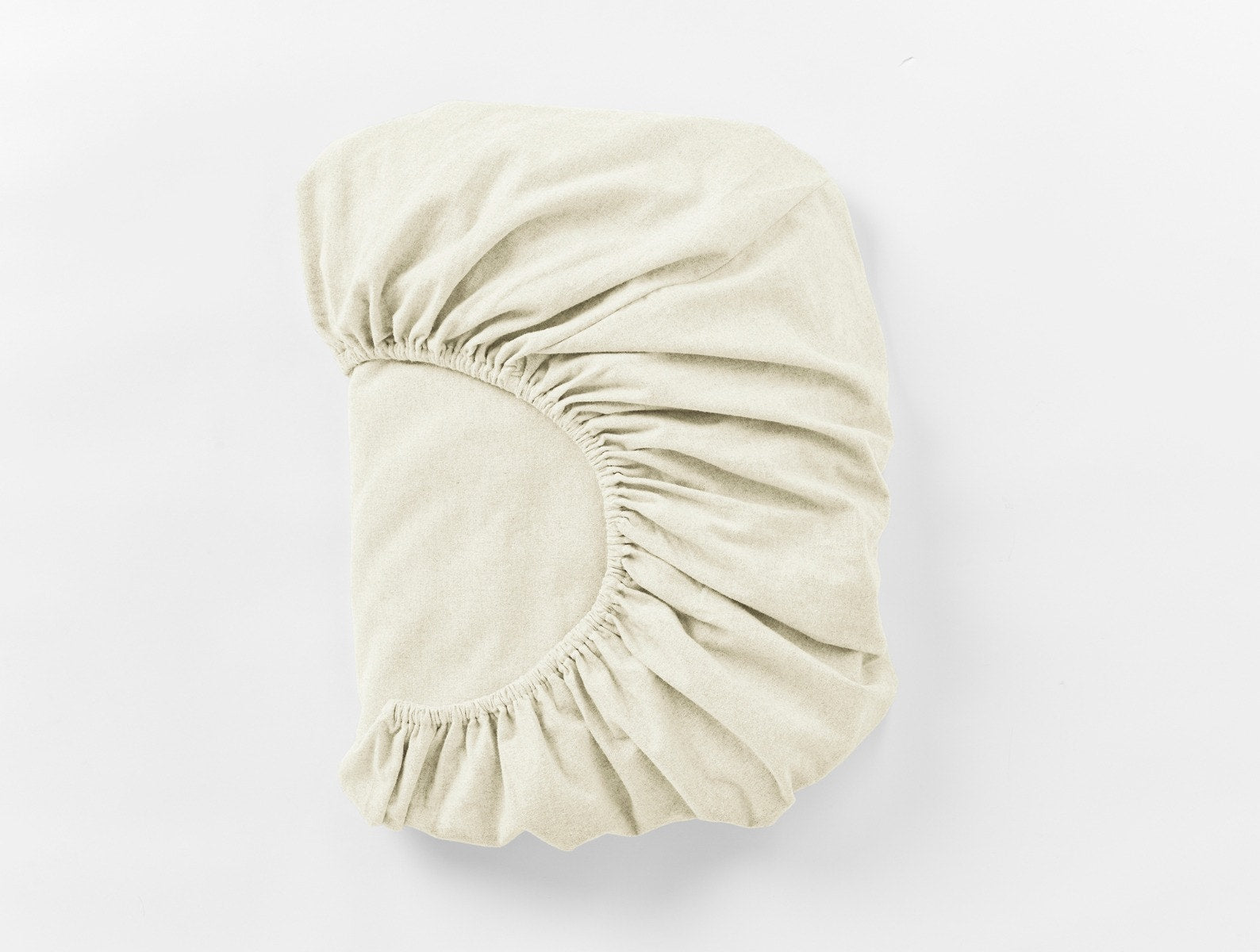 Coyuchi Cloud Brushed Organic Flannel Fitted Sheet in Undyed – folded, displaying elastic in seam. #colour_undyed