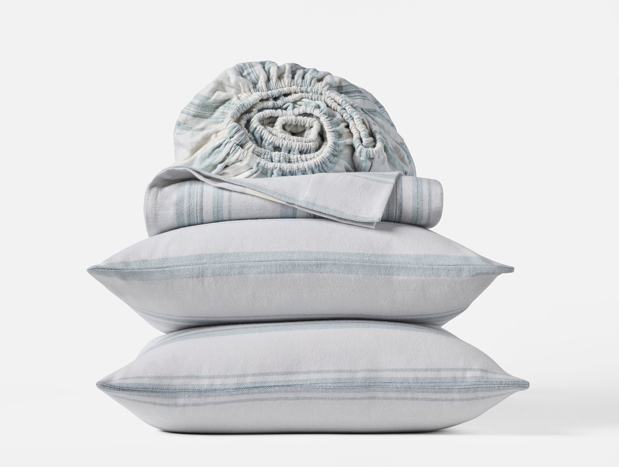Coyuchi Cloud Brushed Organic Flannel Sheet Set in Gulf Herringbone Stripe – stacked display with pillows and folded sheets. #colour_gulf herringbone stripe
