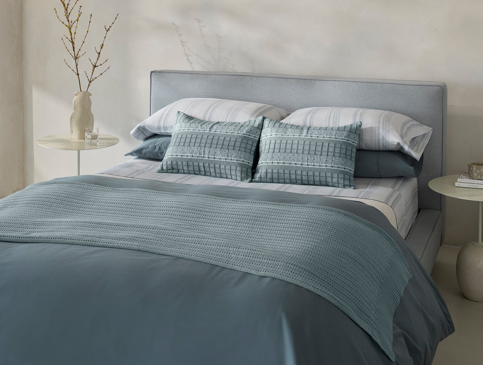 Coyuchi Cloud Brushed Organic Flannel Sheet Set in Gulf Herringbone Stripe – styled on bed in natural light paired with blue bedding accessories. #colour_gulf herringbone stripe