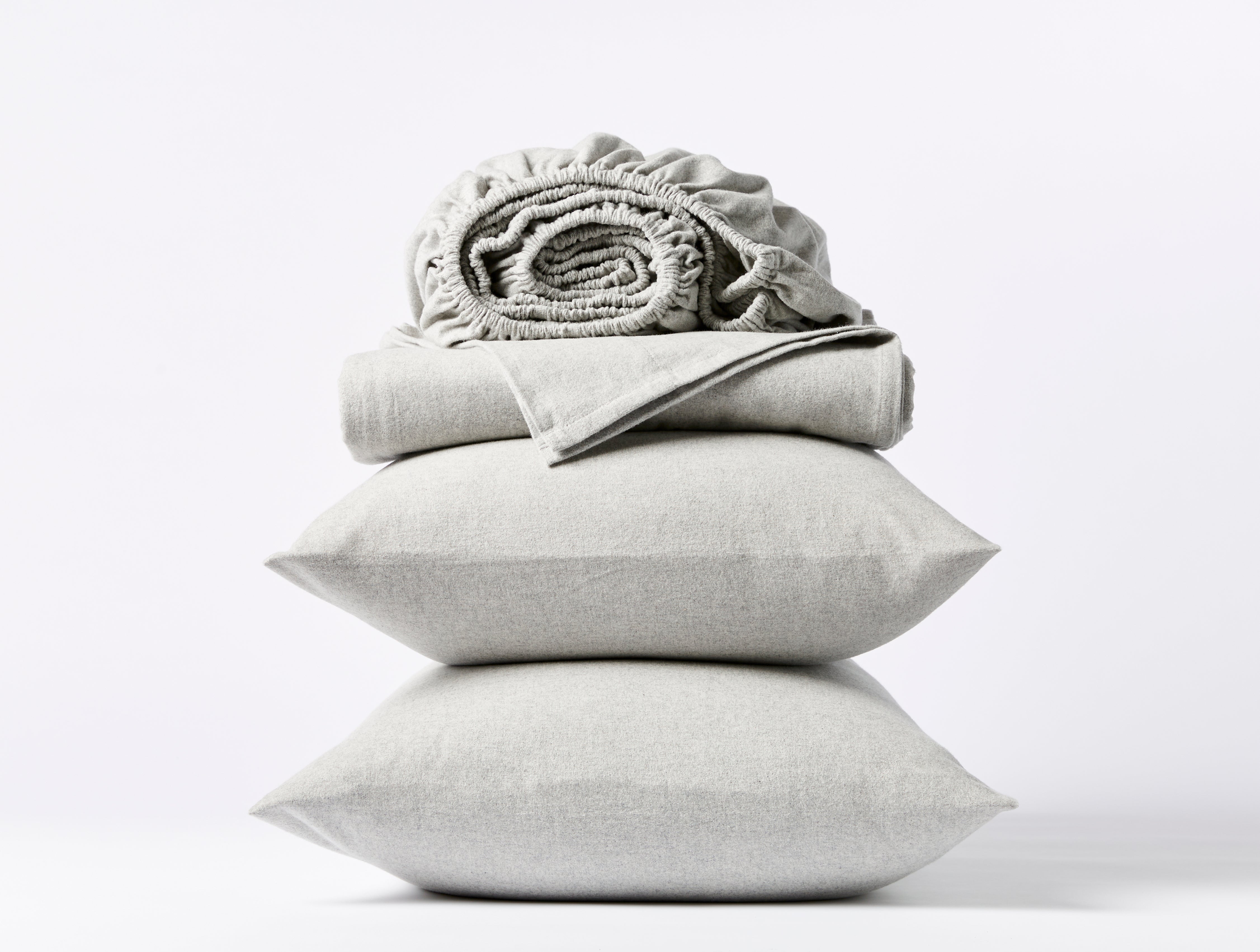 Coyuchi Cloud Brushed Organic Flannel Sheet Set in Pale Grey Heather – stacked display with pillows and folded sheets. #colour_pale gray heather