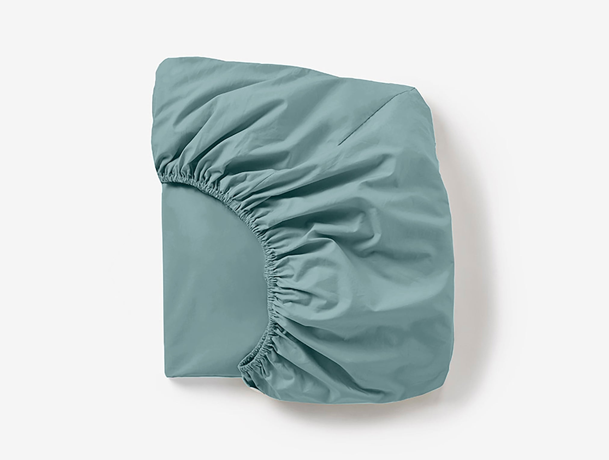Coyuchi Cloud Soft Organic Sateen Fitted Sheet in Pacific Blue – folded, displaying elastic in seam. #colour_pacific blue