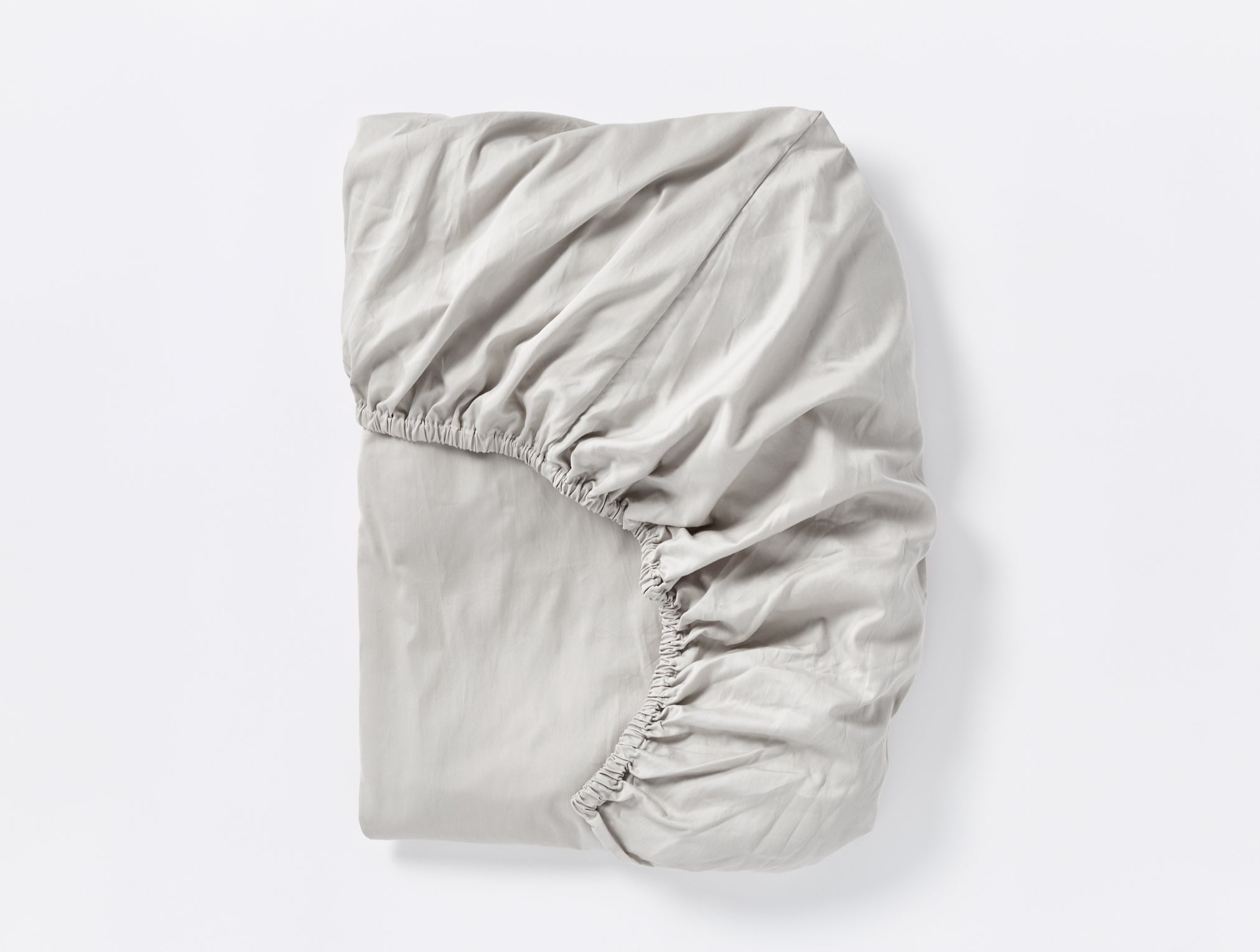 Coyuchi Cloud Soft Organic Sateen Fitted Sheet in Pale Grey – folded, displaying elastic in seam. #colour_pale gray