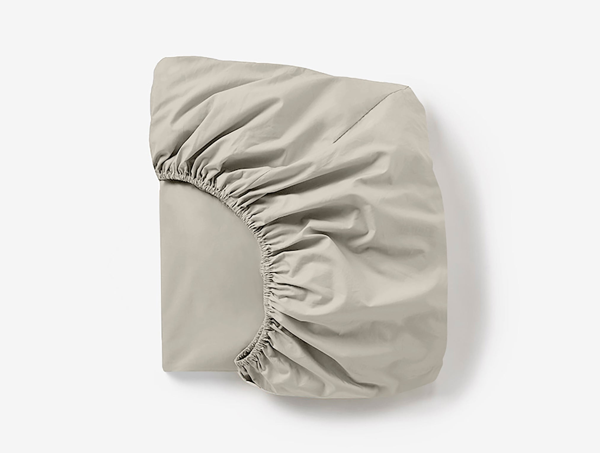 Coyuchi Cloud Soft Organic Sateen Fitted Sheet in Stone– folded, displaying elastic in seam. #colour_stone