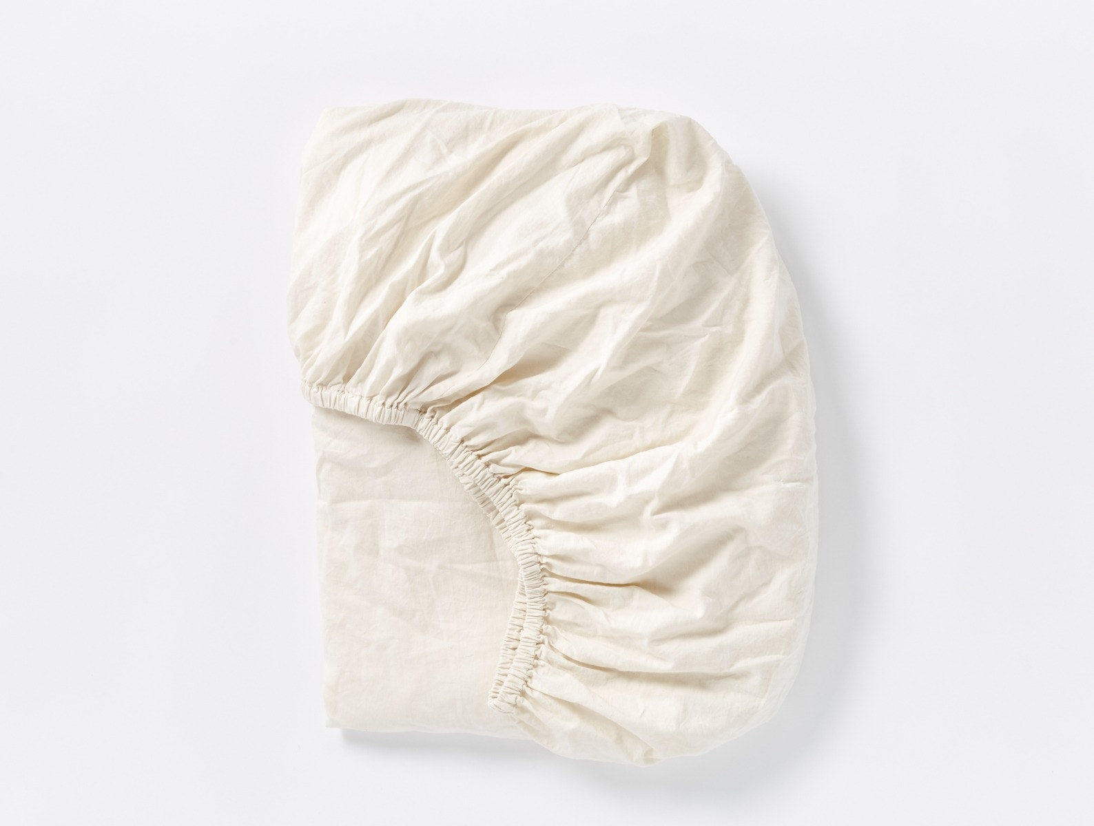 Coyuchi Cloud Soft Organic Sateen Fitted Sheet in Undyed – folded, displaying elastic in seam. #colour_undyed