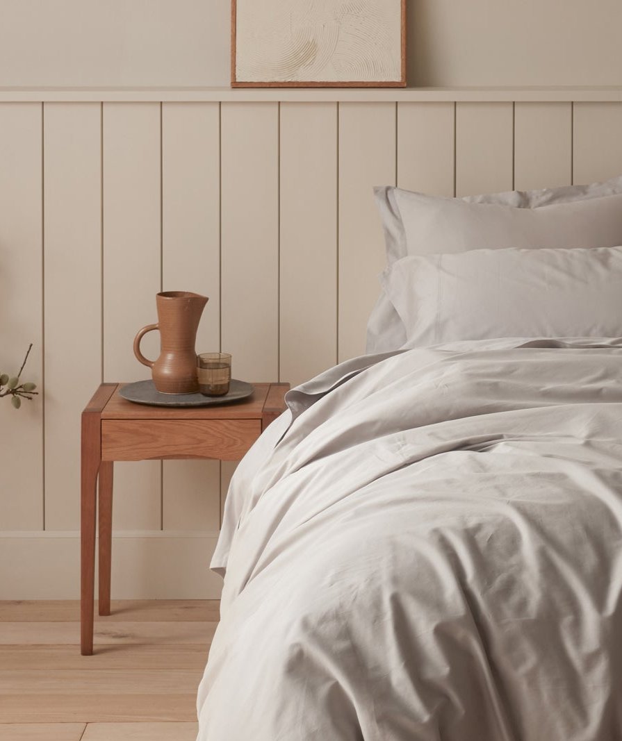 Coyuchi Cloud Soft Organic Sateen Sheet Set in Pale Grey – detail frame of made bed showing relaxed texture. #colour_pale grey