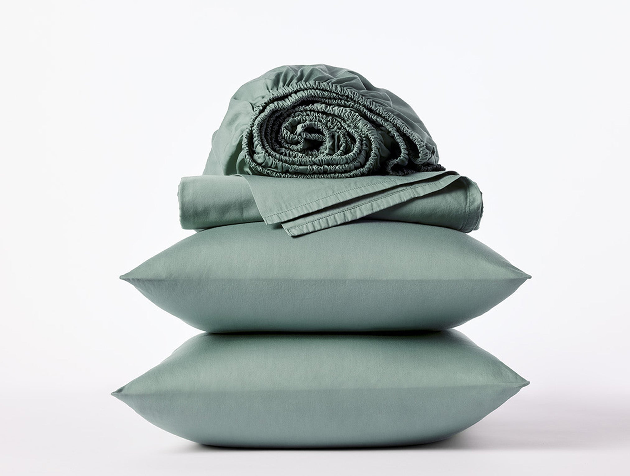 Coyuchi Cloud Soft Organic Sateen Sheet Set in Sage – stacked display with pillows and folded sheets. #colour_sage