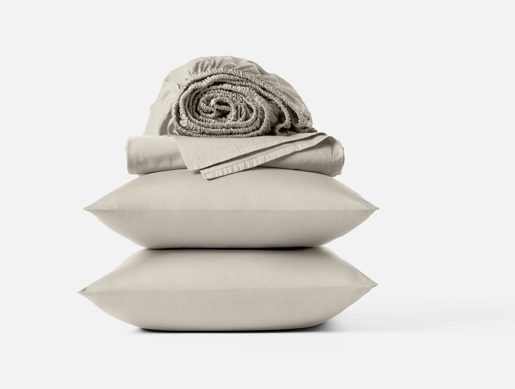 Coyuchi Cloud Soft Organic Sateen Sheet Set in Stone – stacked display with pillows and folded sheets. #colour_stone