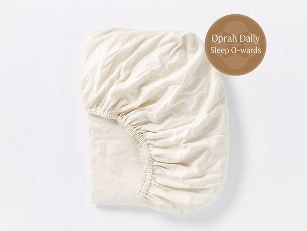 Coyuchi Cloud Soft Organic Sateen Fitted Sheet in Undyed – folded, displaying elastic in seam. #colour_none
