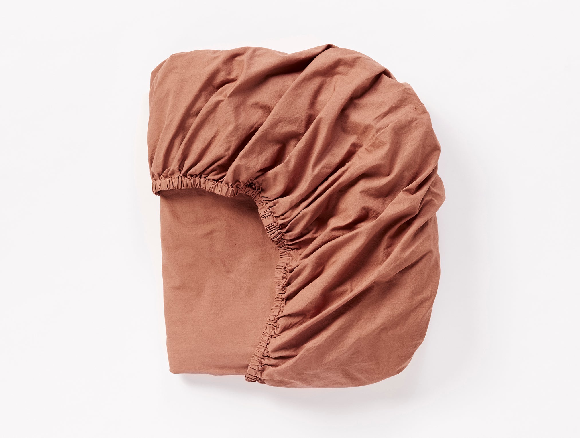 Coyuchi Organic Crinkled Percale Fitted Sheet in Sedona – folded to display elastic in seam. #colour_sedona