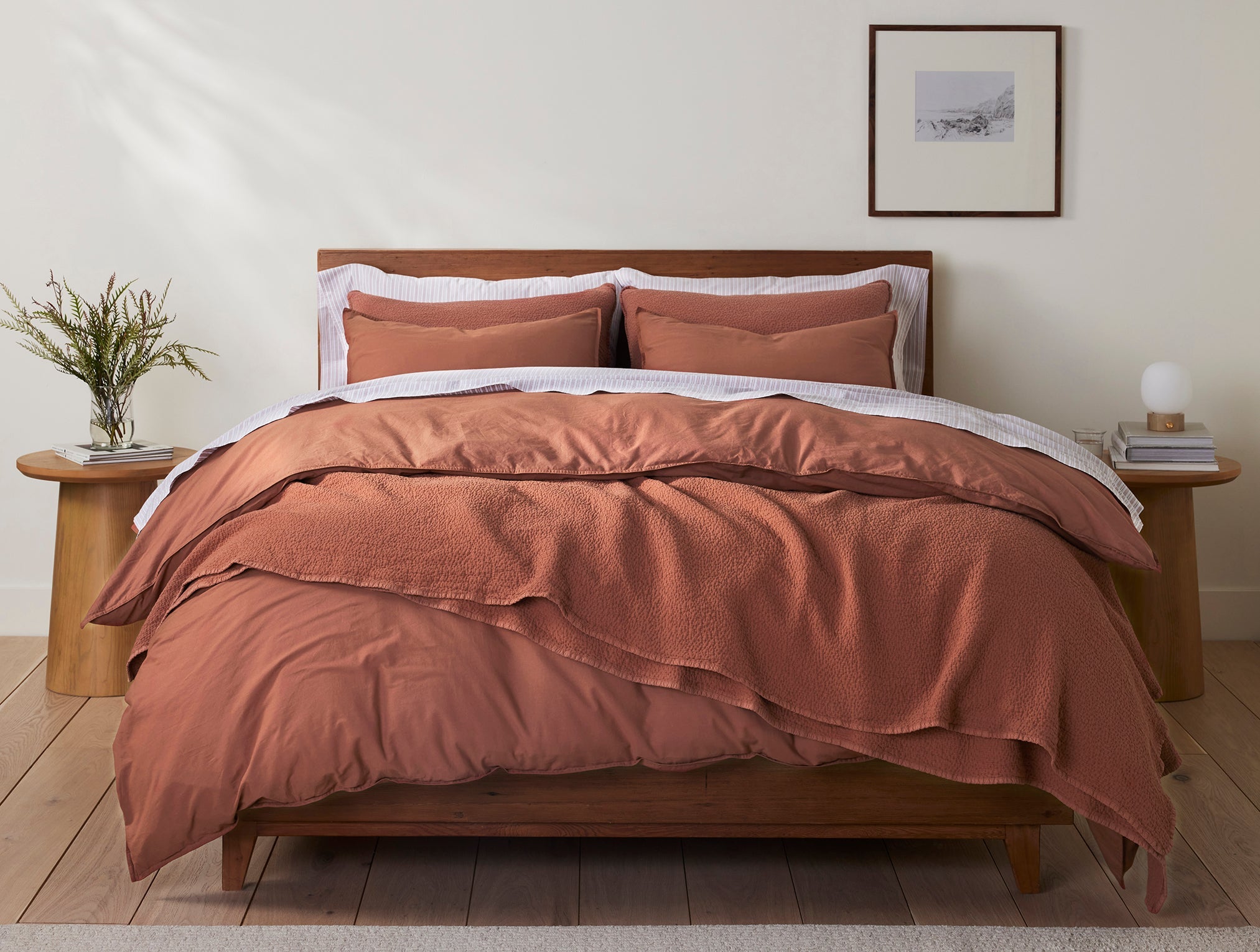 Coyuchi Organic Crinkled Percale Fitted Sheet in Sedona – made bed, styled with natural wood bed frame and side tables. #colour_sedona