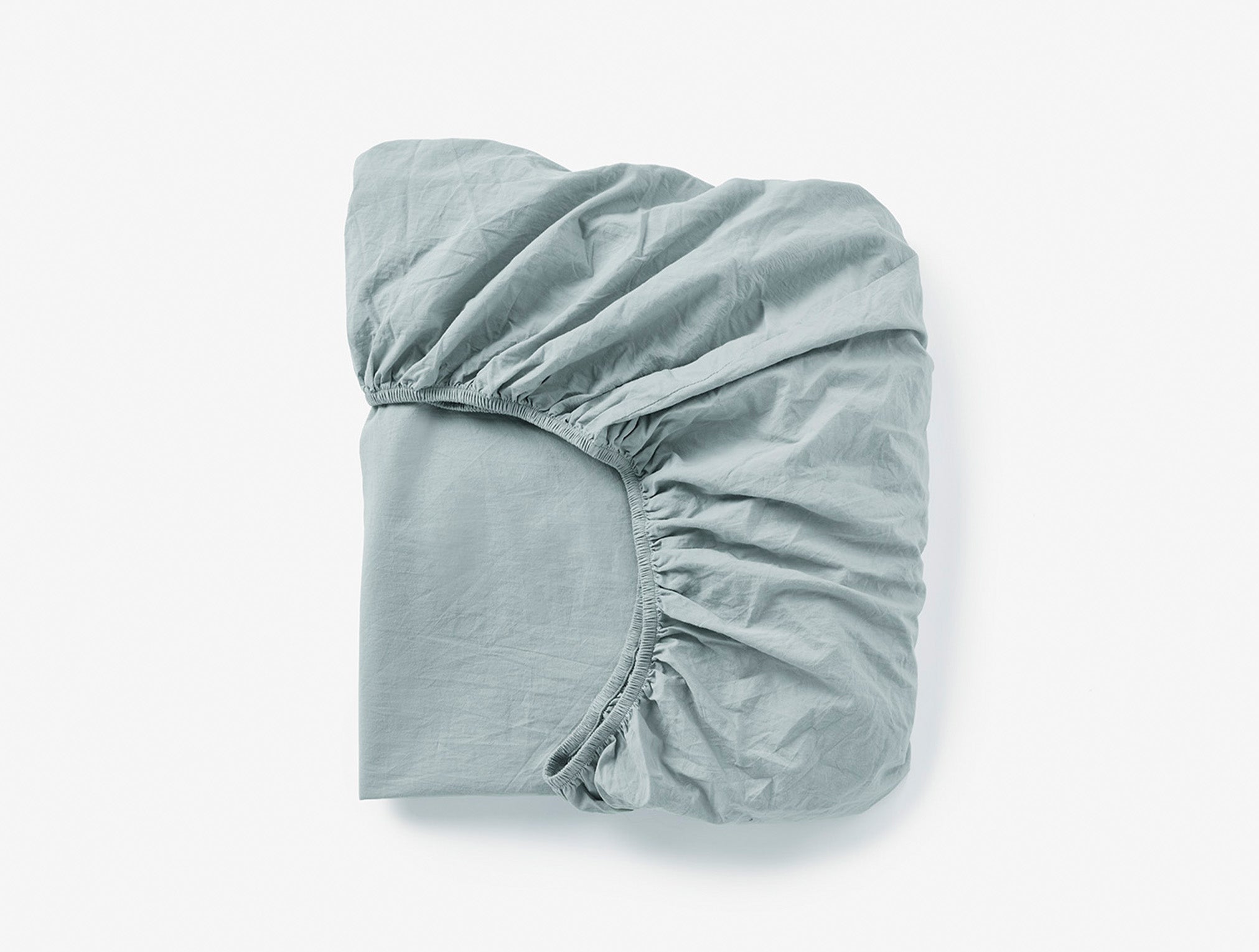Coyuchi Organic Crinkled Percale Fitted Sheet in Surf Chambray – folded to display elastic in seam. #colour_surf chambray