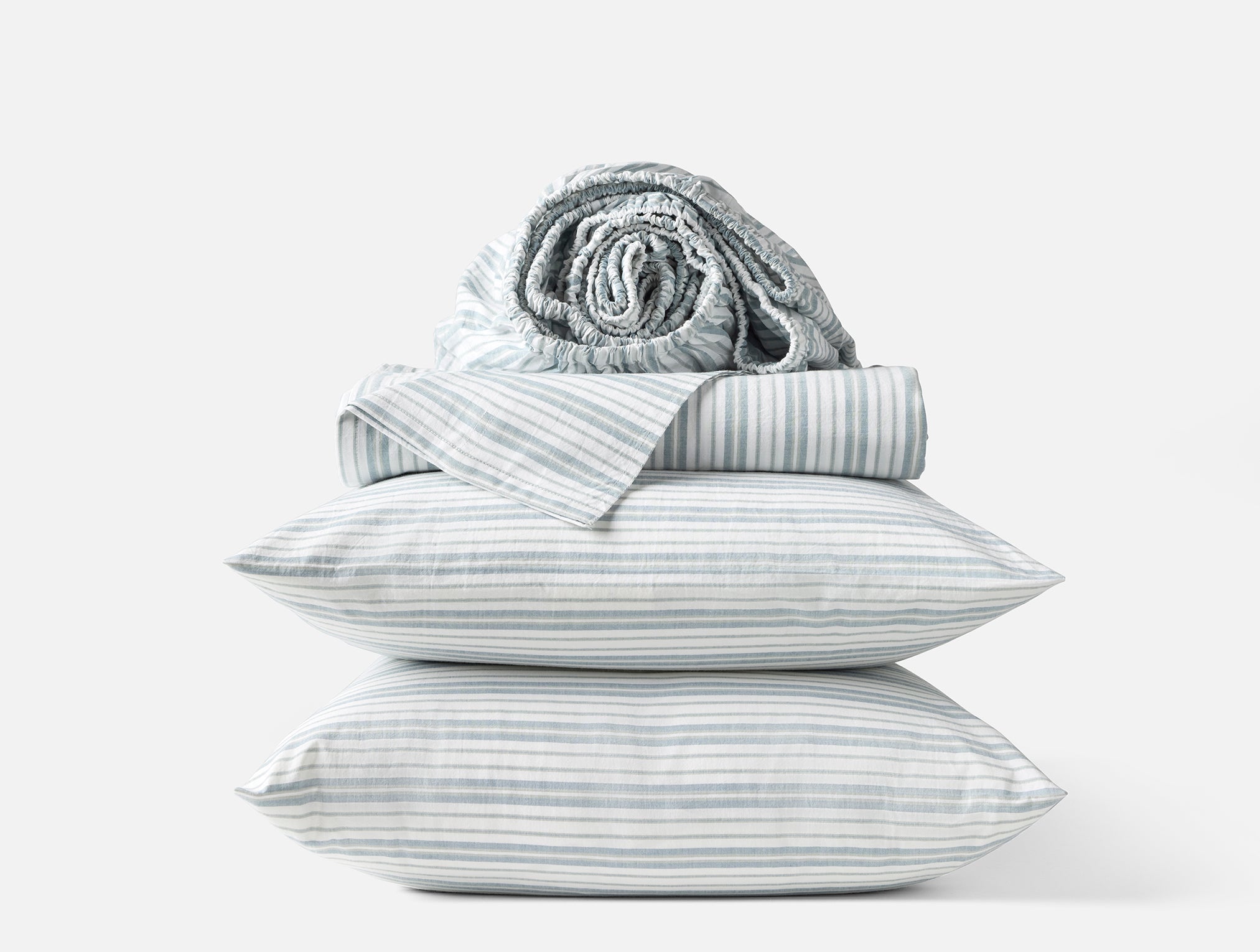 Coyuchi Organic Crinkled Percale Sheet Set in Pacific Blue Stripe – stacked display with pillows and folded sheets. #colour_pacific blue stripe