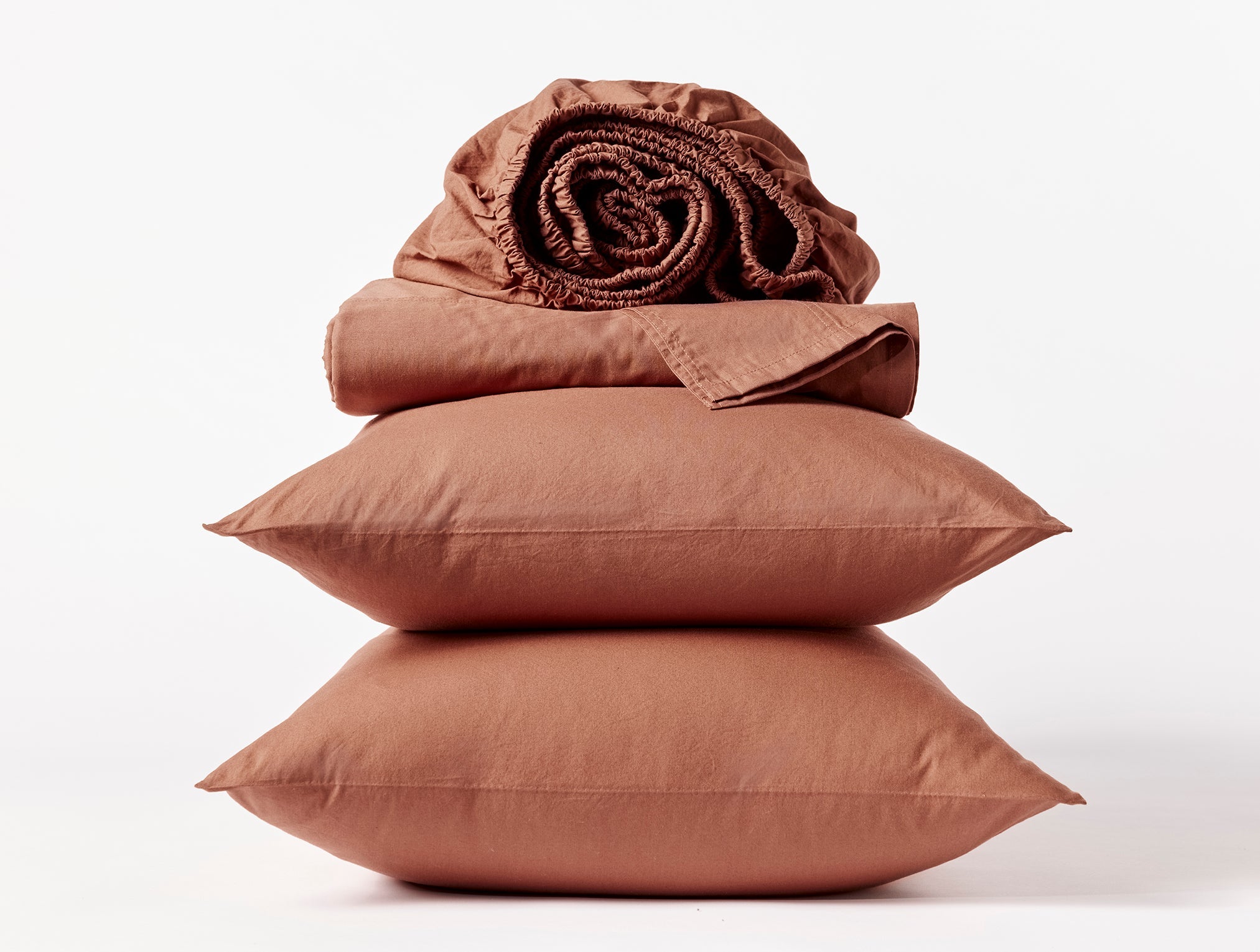 Coyuchi Organic Crinkled Percale Sheet Set in Sedona – stacked display with pillows and folded sheets. #colour_sedona