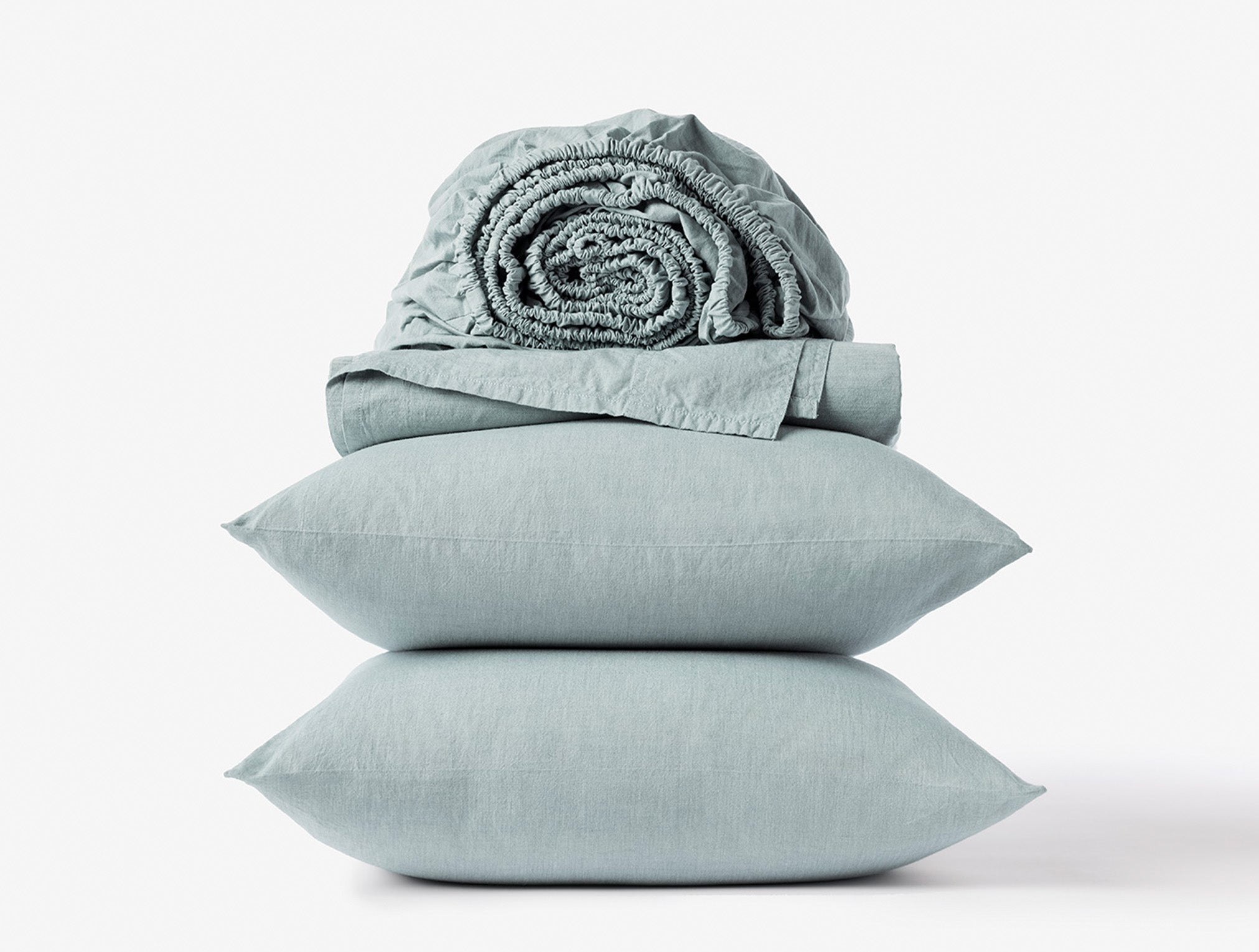 Coyuchi Organic Crinkled Percale Sheet Set in Surf Chambray – stacked display with pillows and folded sheets. #colour_surf chambray