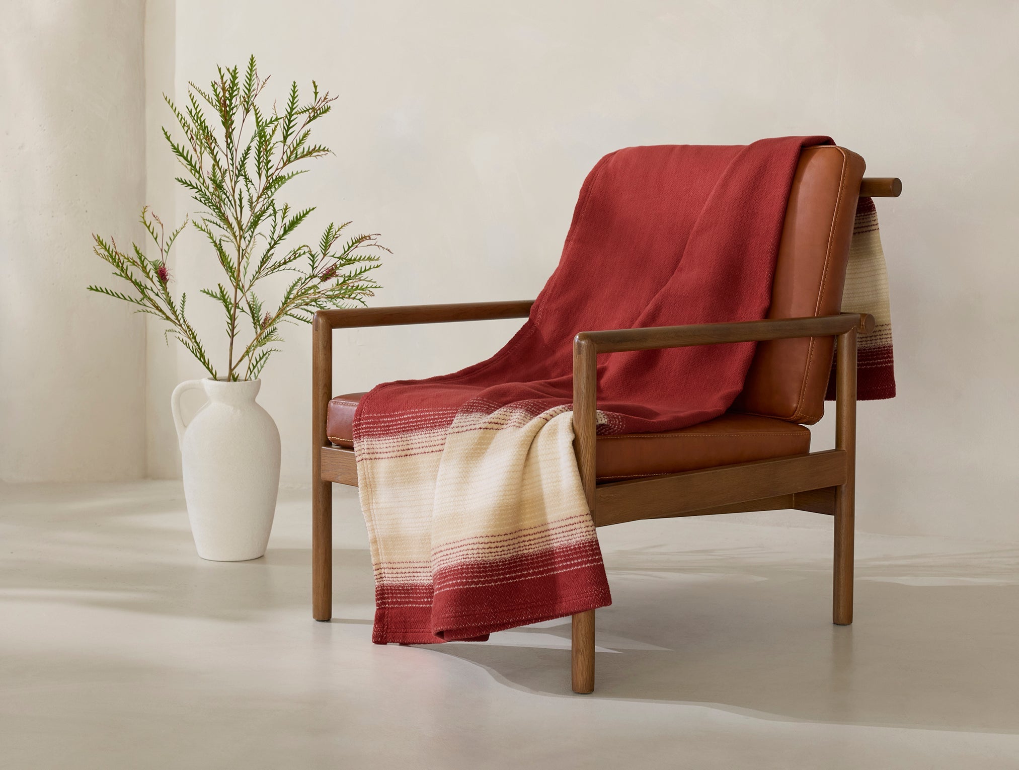 Coyuchi Horizon Supersoft Organic Throw - draped over wooden chair #colour_Claret Ombre
