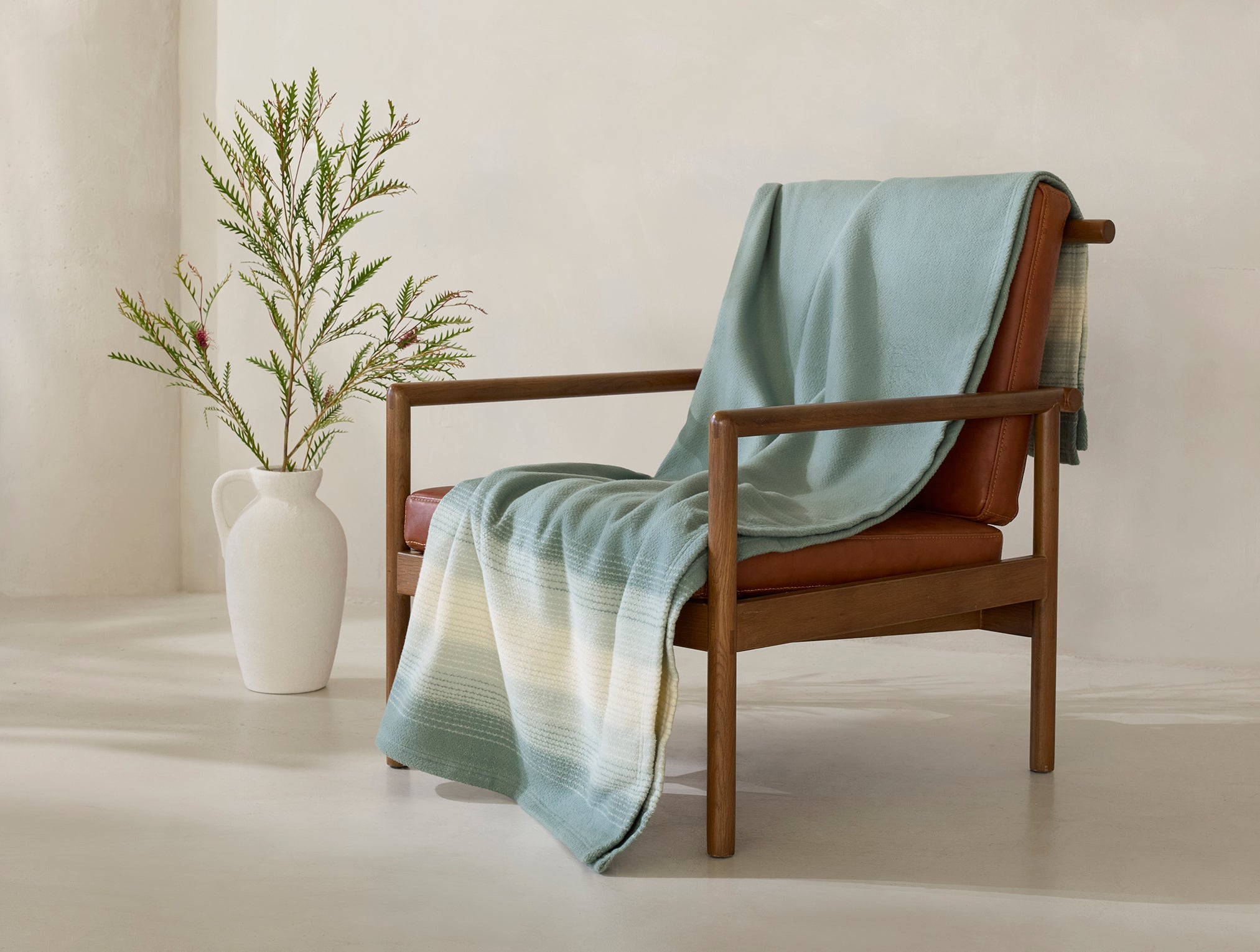 Coyuchi Horizon Supersoft Organic Throw - draped over chair #colour_Surf Ombre