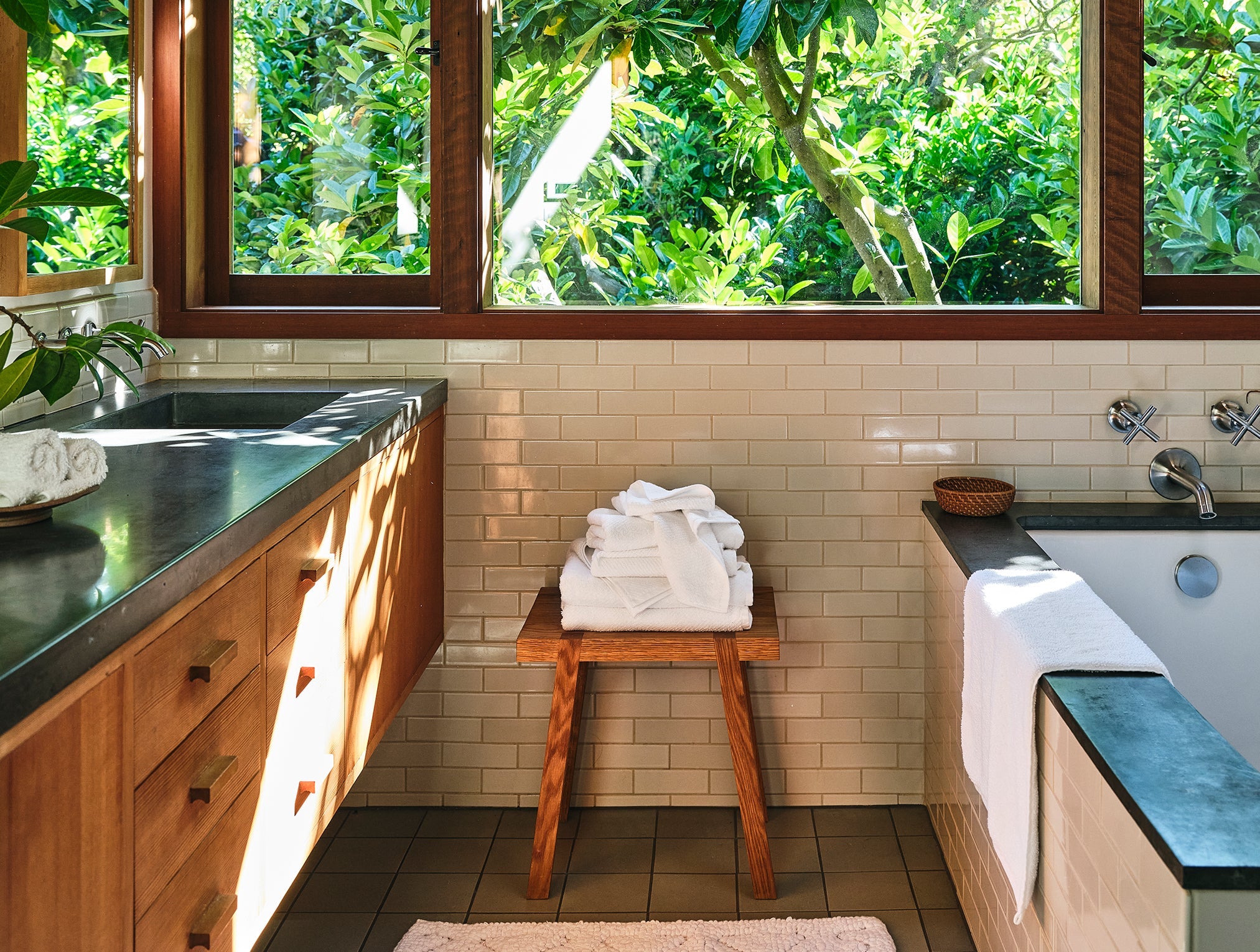 Coyuchi Organic Air Weight Towel - stacked on wood table in bathroom next to tub #color_alpine white