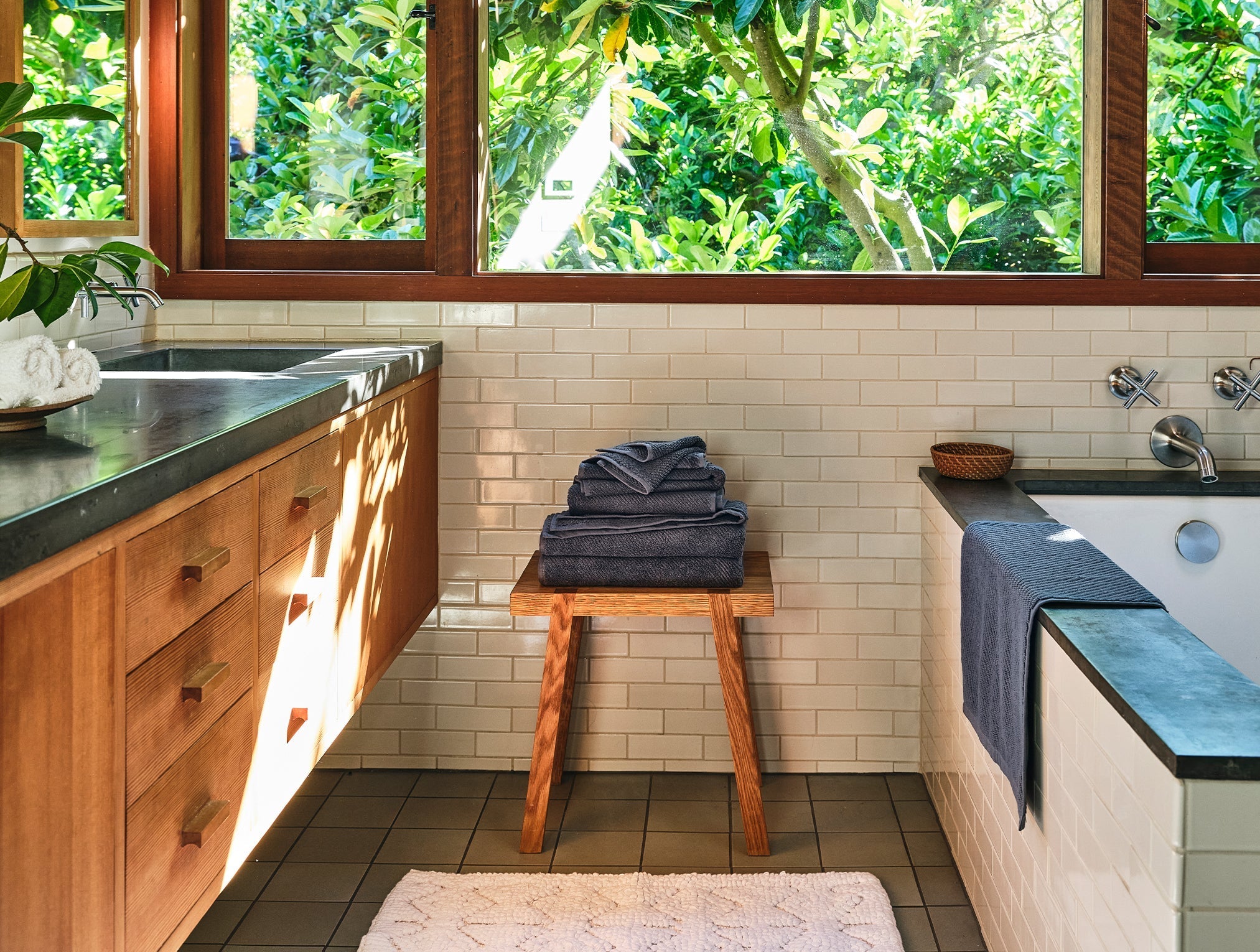 Coyuchi Organic Air Weight Towel - stacked on wooden stool in bathroom beside tub #color_gulf