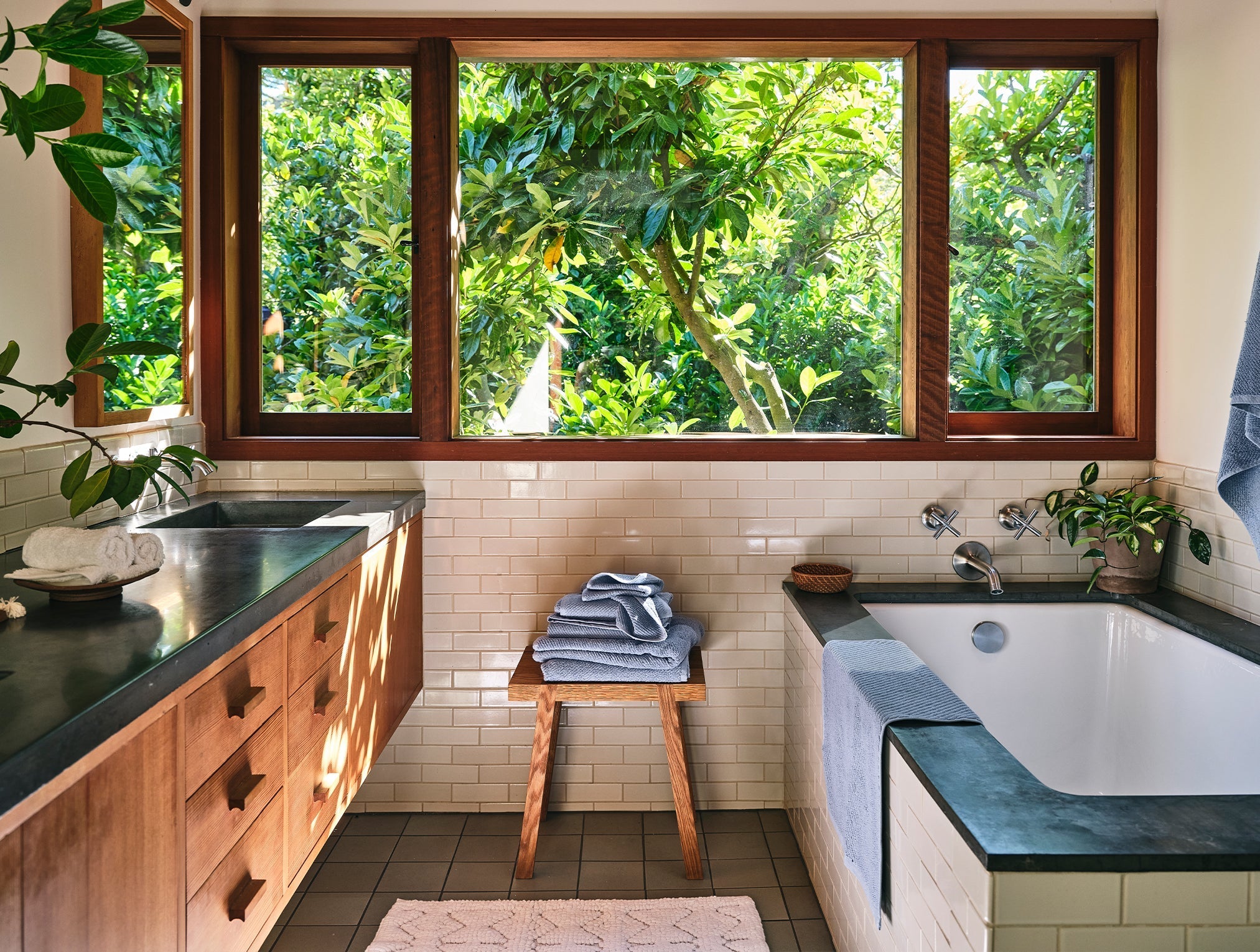 Coyuchi Organic Air Weight Towel - stacked on table in bathroom beside tub and sink #color_stone blue
