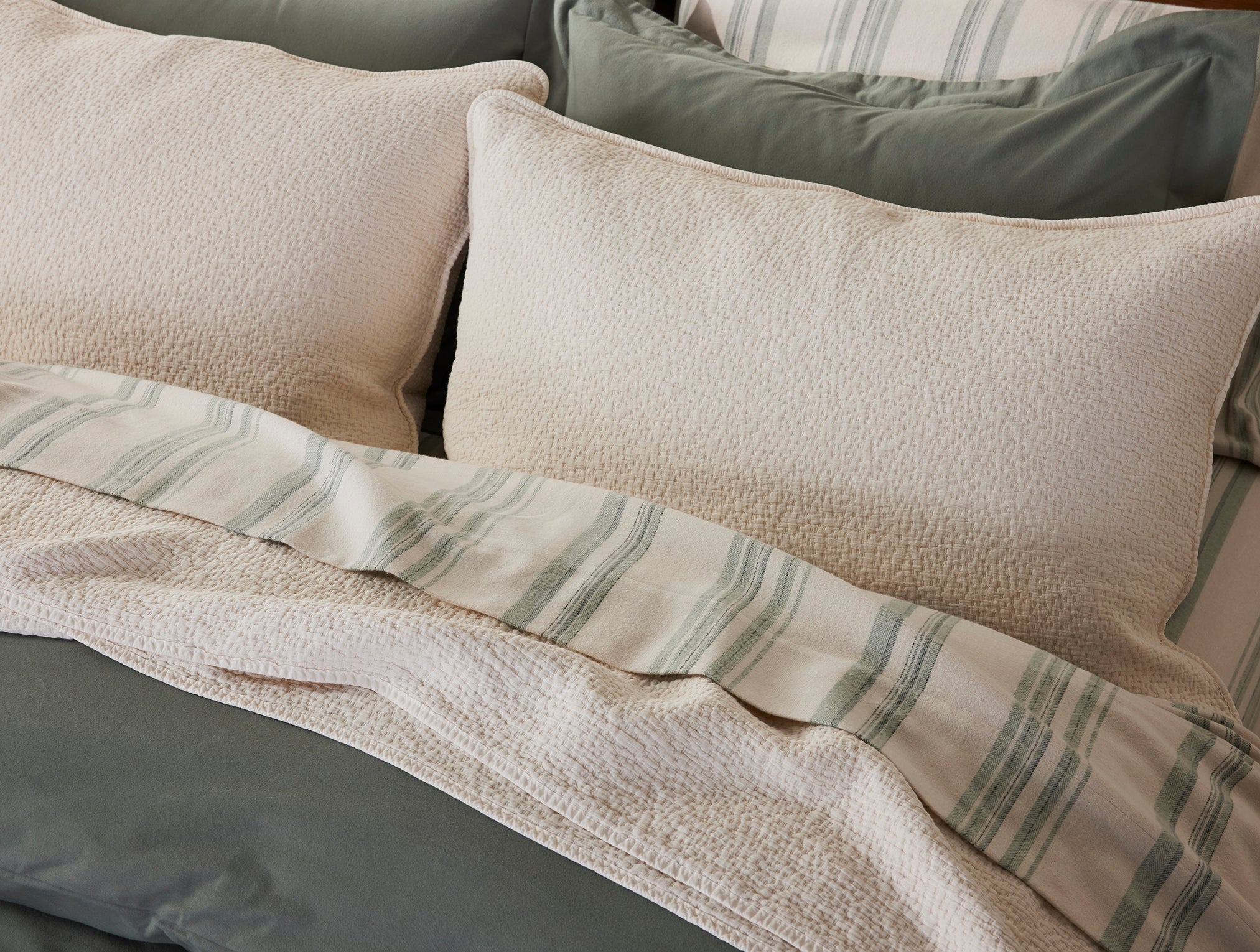 Coyuchi Organic Cascade Matelasse Blanket - staged bed with matching pillows #colour_Undyed
