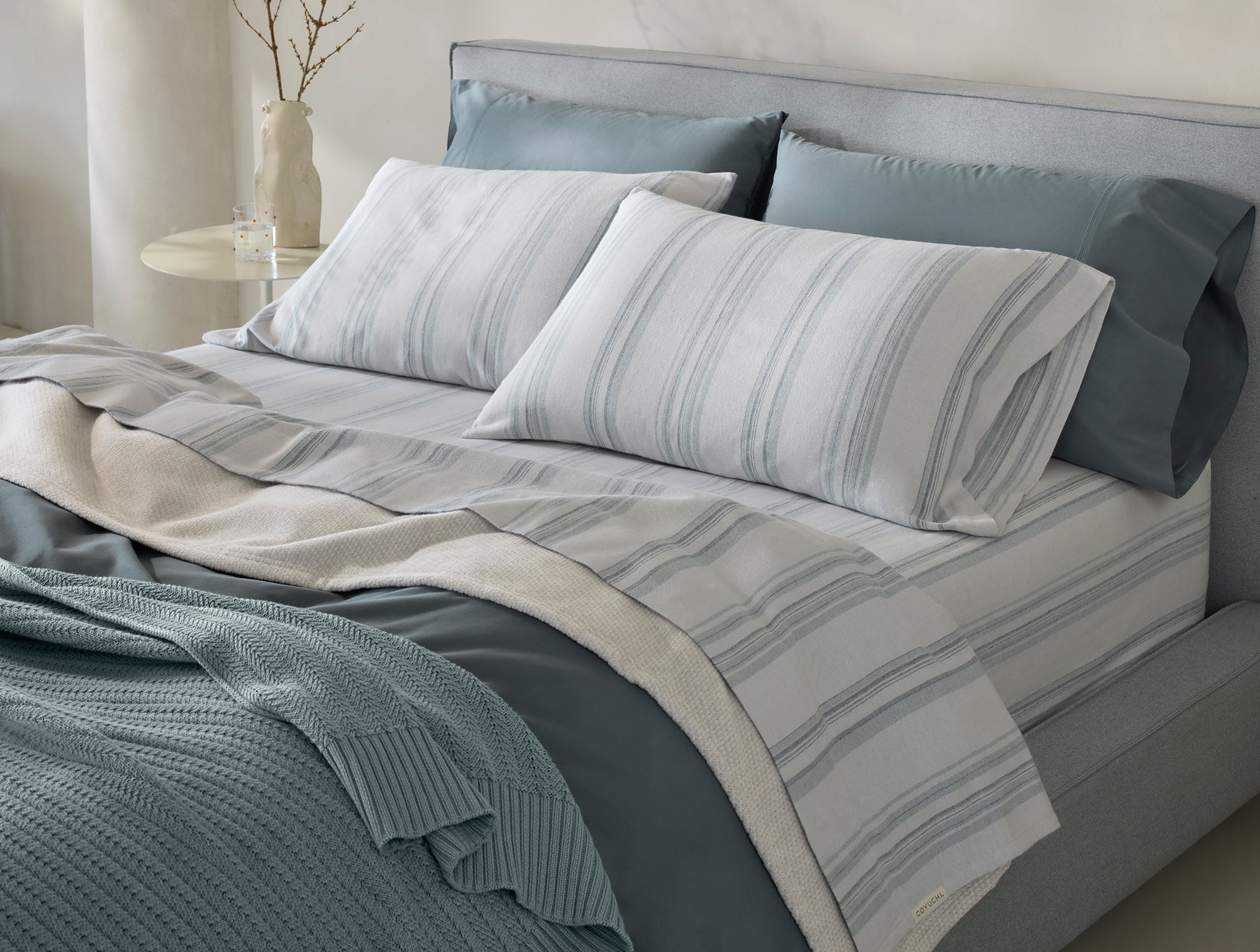 Coyuchi Organic Cloud Brushed Flannel Pillowcase - staged bed soft light from window #colour_gulf herringbone stripe