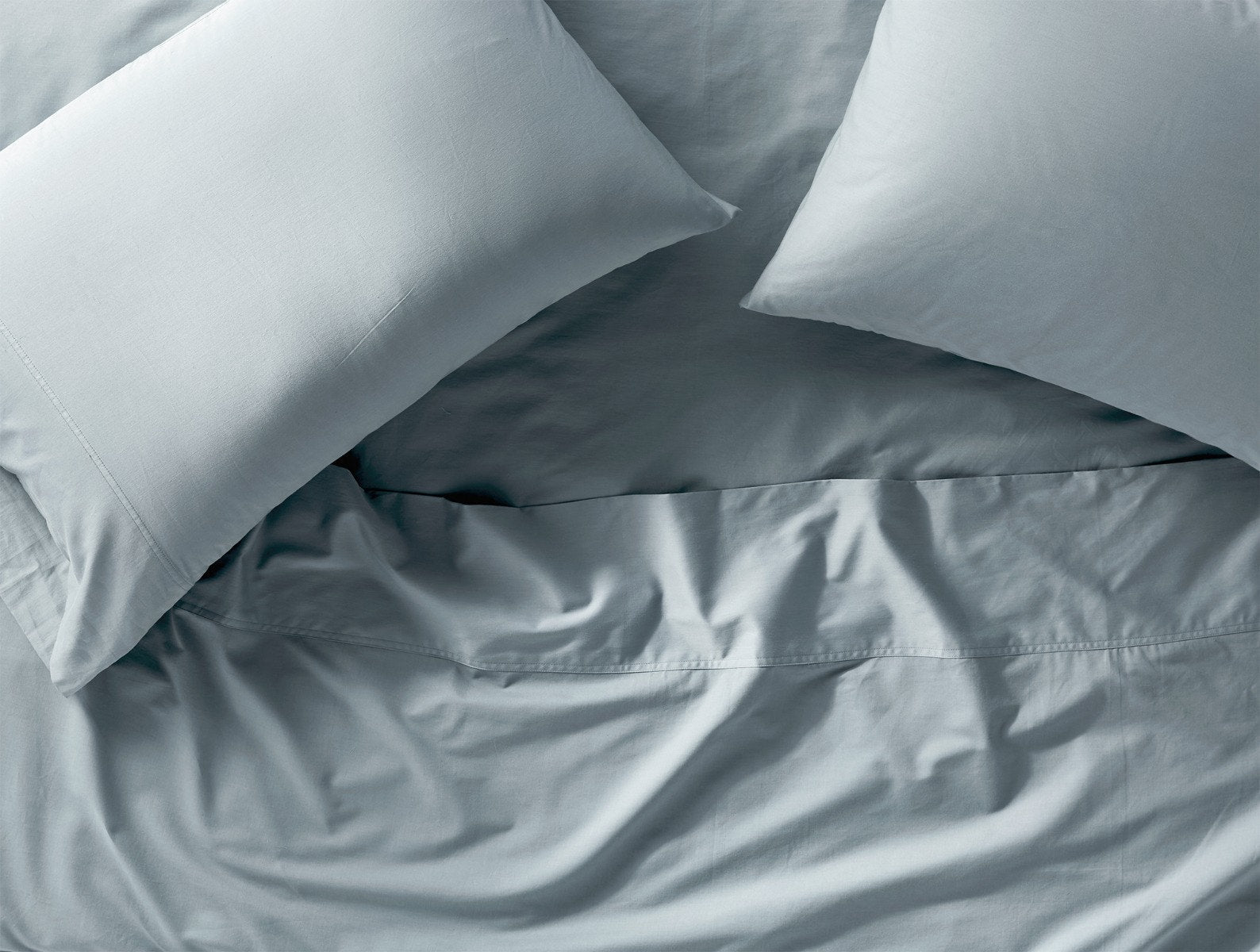 Coyuchi Organic Cloud Soft Sateen Pillowcase - pillows with matching sheet set done up on bed #colour_pale ocean