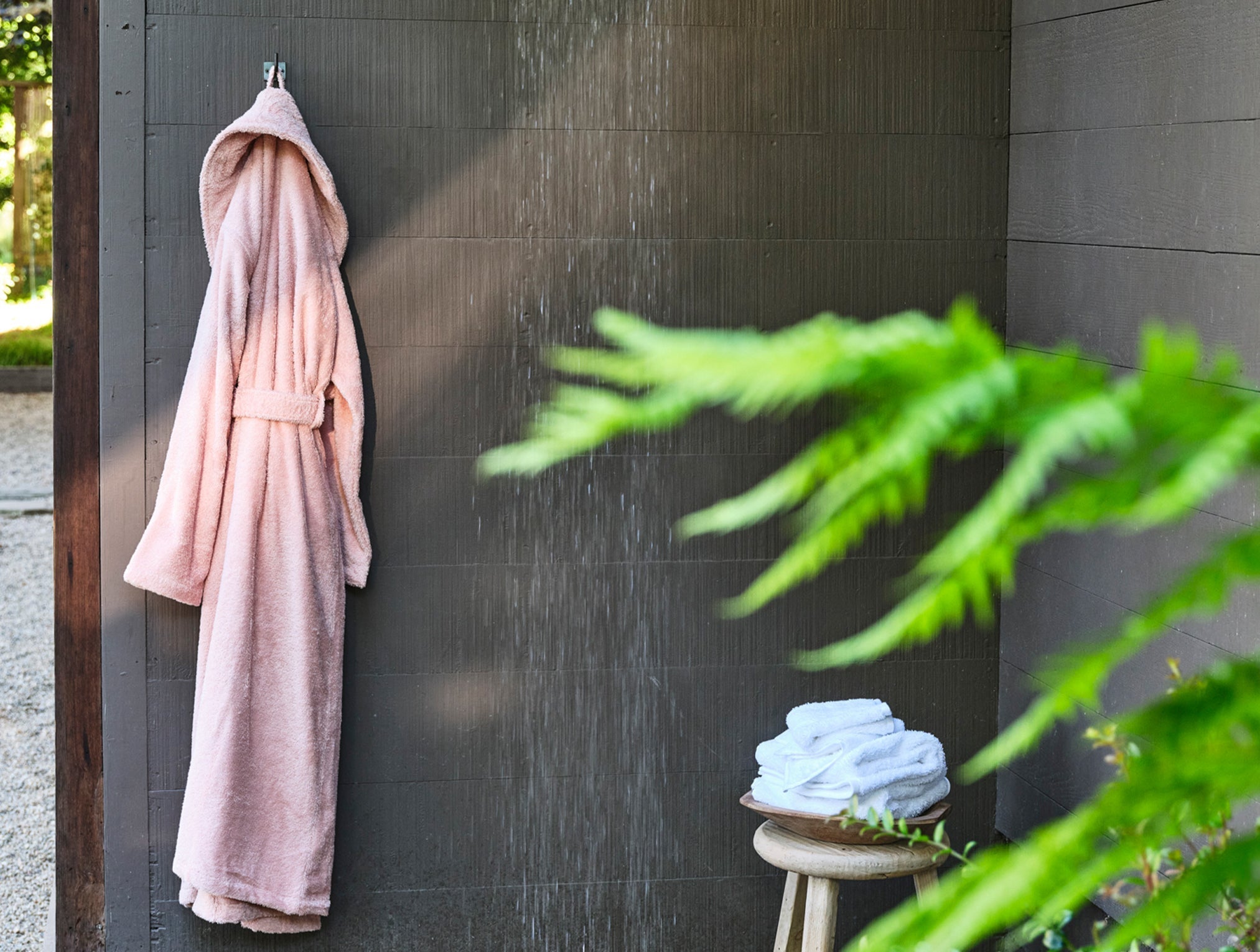 Coyuchi Organic Cotton Unisex Cloud Loom Robe - hanging in outdoor shower #colour_cherry blossom