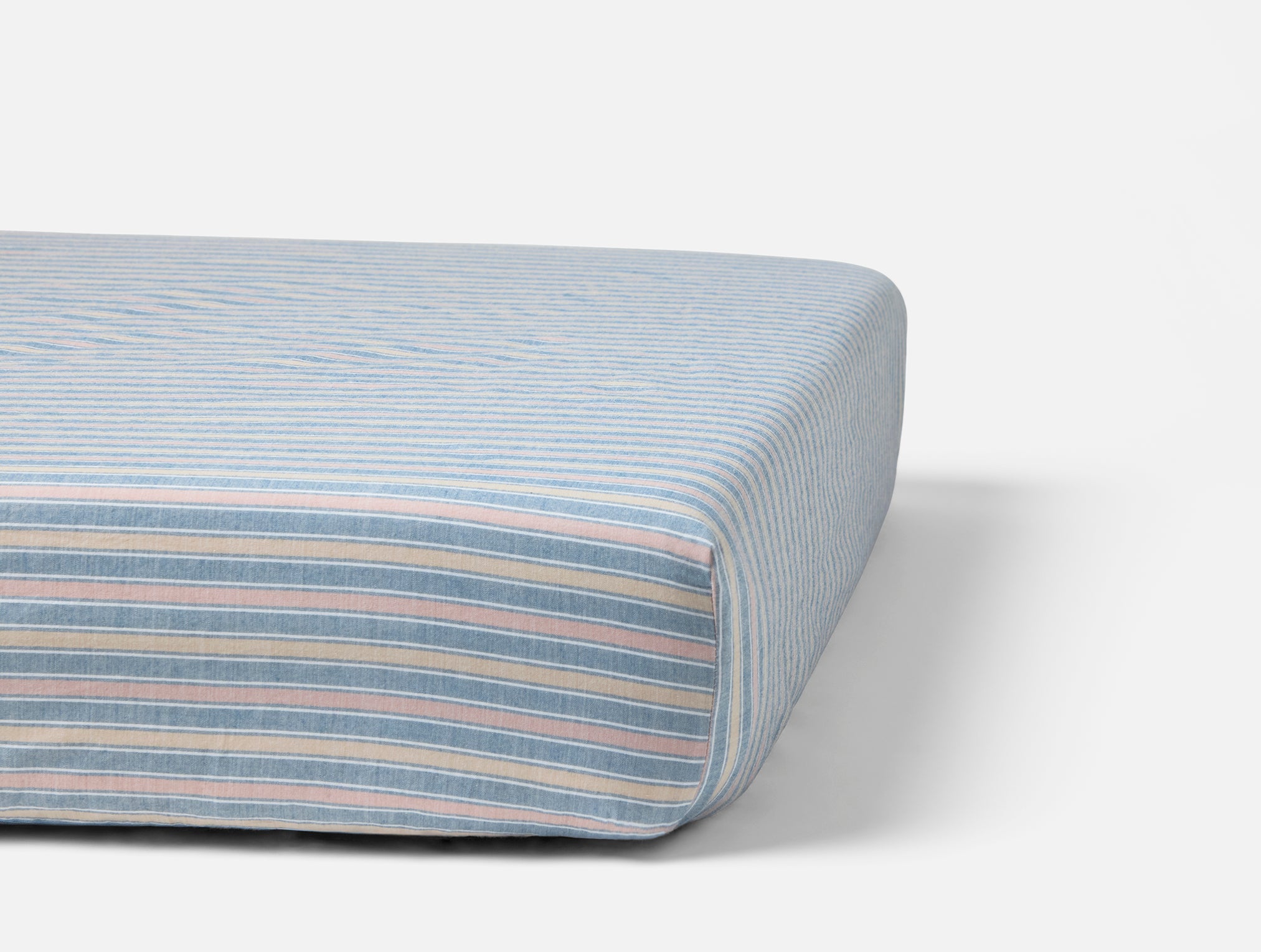 Coyuchi Organic Cotton Crinkled Percale Crib Sheet in Indigo Stripe - on crib mattress #colour_indigo stripe