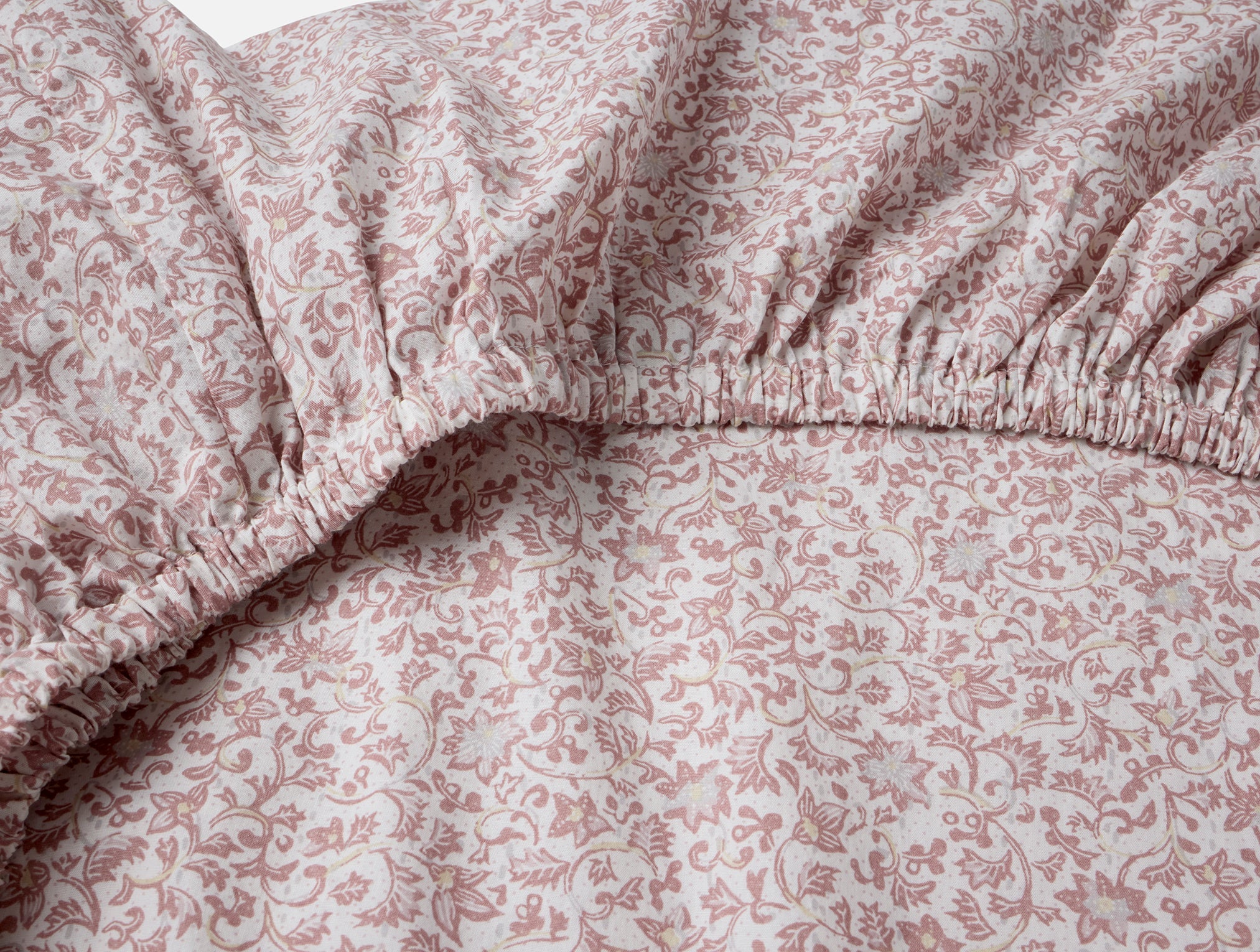 Coyuchi Organic Cotton Crinkled Percale Crib Sheet in plum blossom - close up of elastic #colour_plum blossom asterid