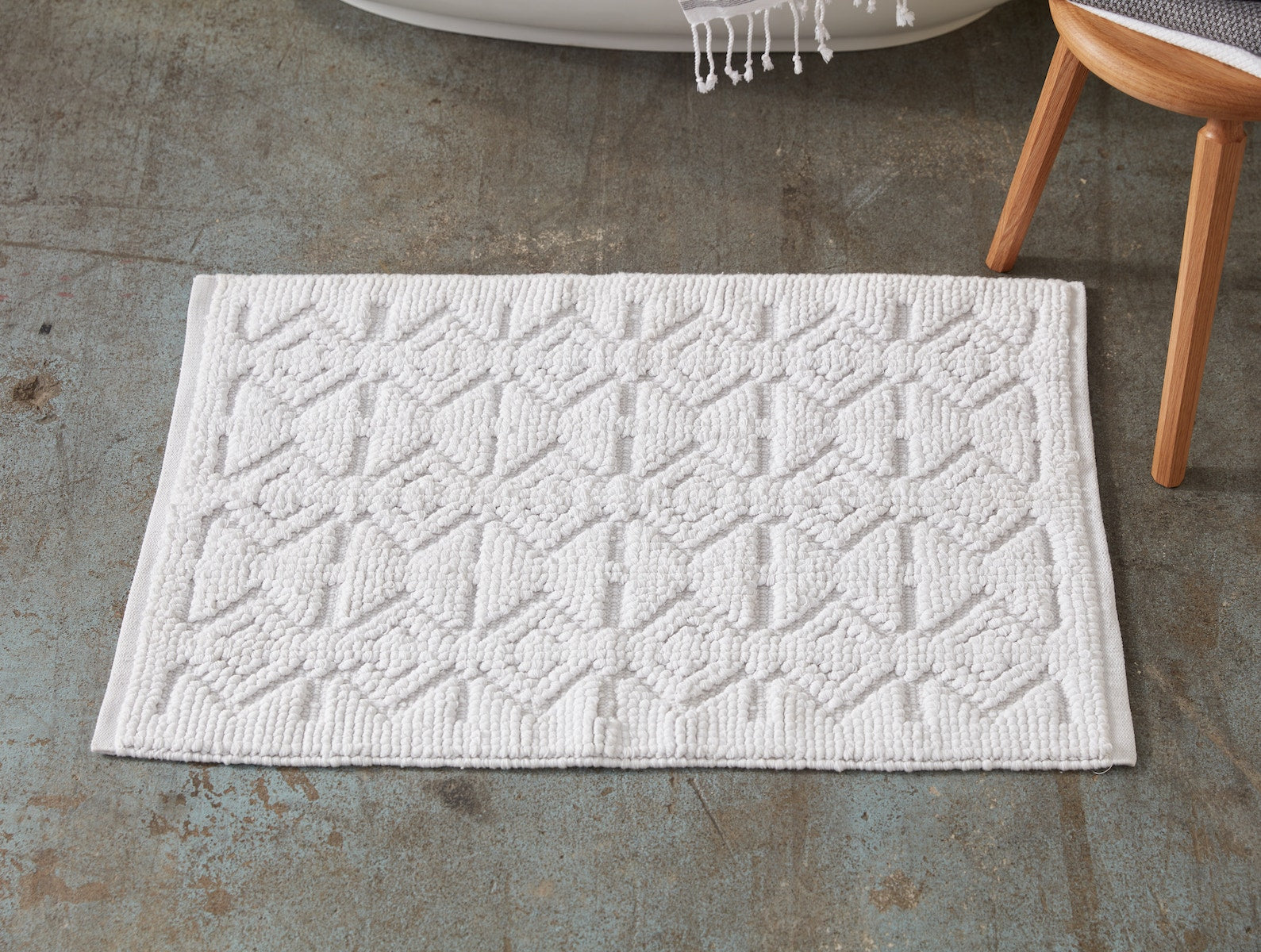 Coyuchi Organic Mosaic Canyon Bath Rug - on floor in front of bath tub #colour_Alpine White w/ Fog