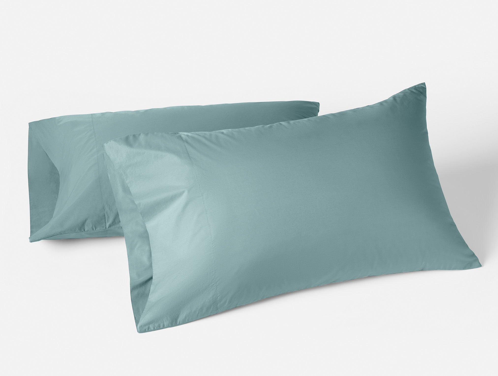 Coyuchi Organic Refined Percale Pillowcase - propped up with white background #colour_pacific blue