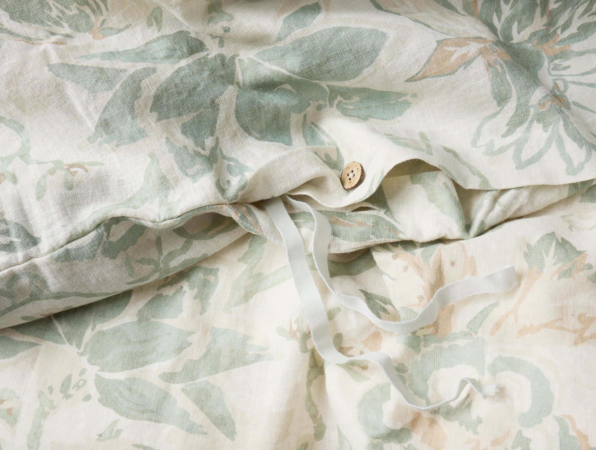 Coyuchi Organic Sea Bloom Print Duvet Cover - close up of bamboo button #colour_Natural w/Sage