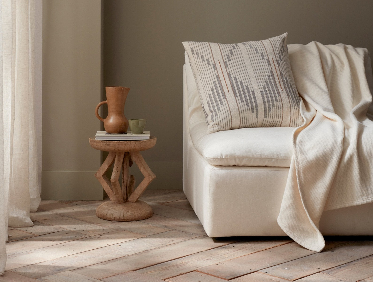 Coyuchi Organic Sequoia Cotton Wool Blanket - staged on couch with wood side table #colour_undyed
