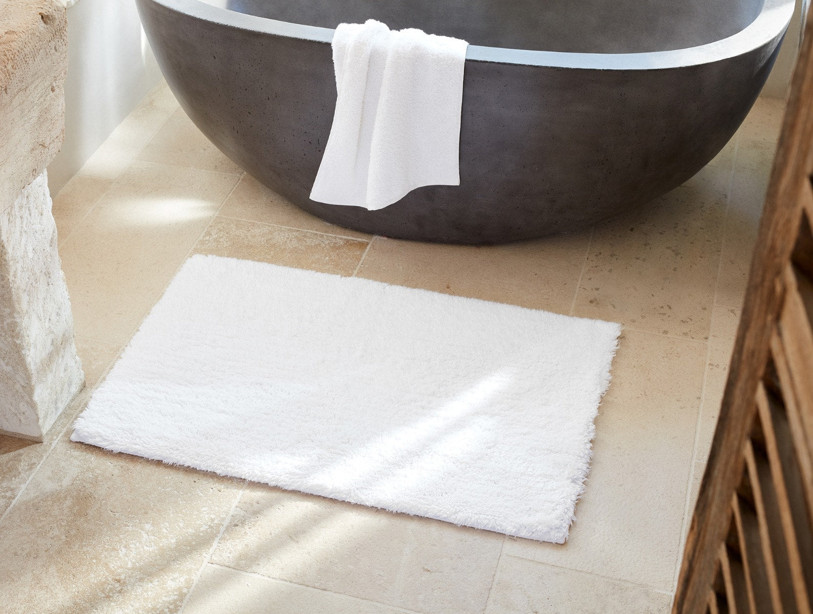 Coyuchi Organic Shag Bath Rug - on floor in front of bath tub #colour_alpine white