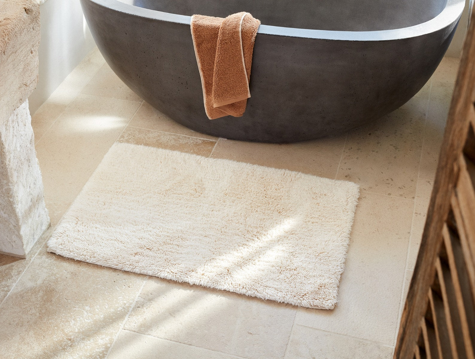 Coyuchi Organic Shag Bath Rug - placed on floor in front of bath tub #colour_undyed