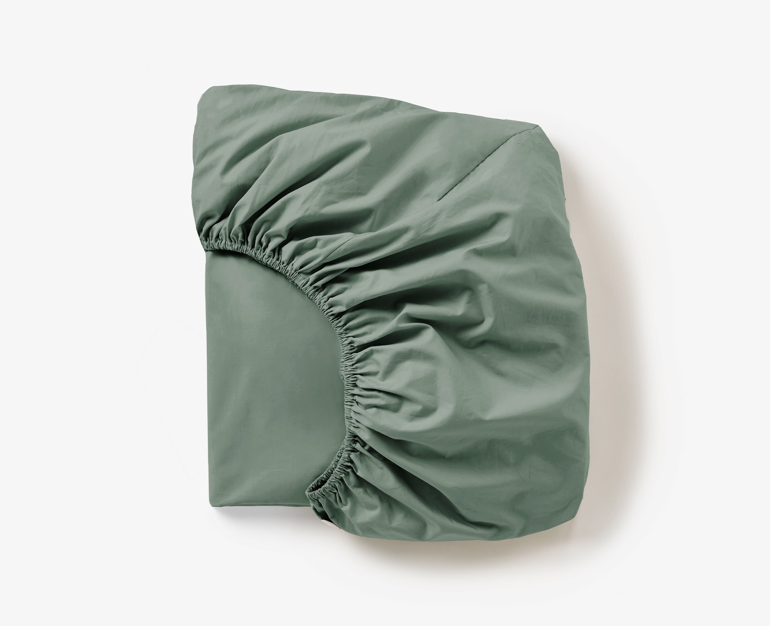 Coyuchi Refined Organic Percale Fitted Sheet in Juniper – folded, displaying elastic in seam. #colour_juniper