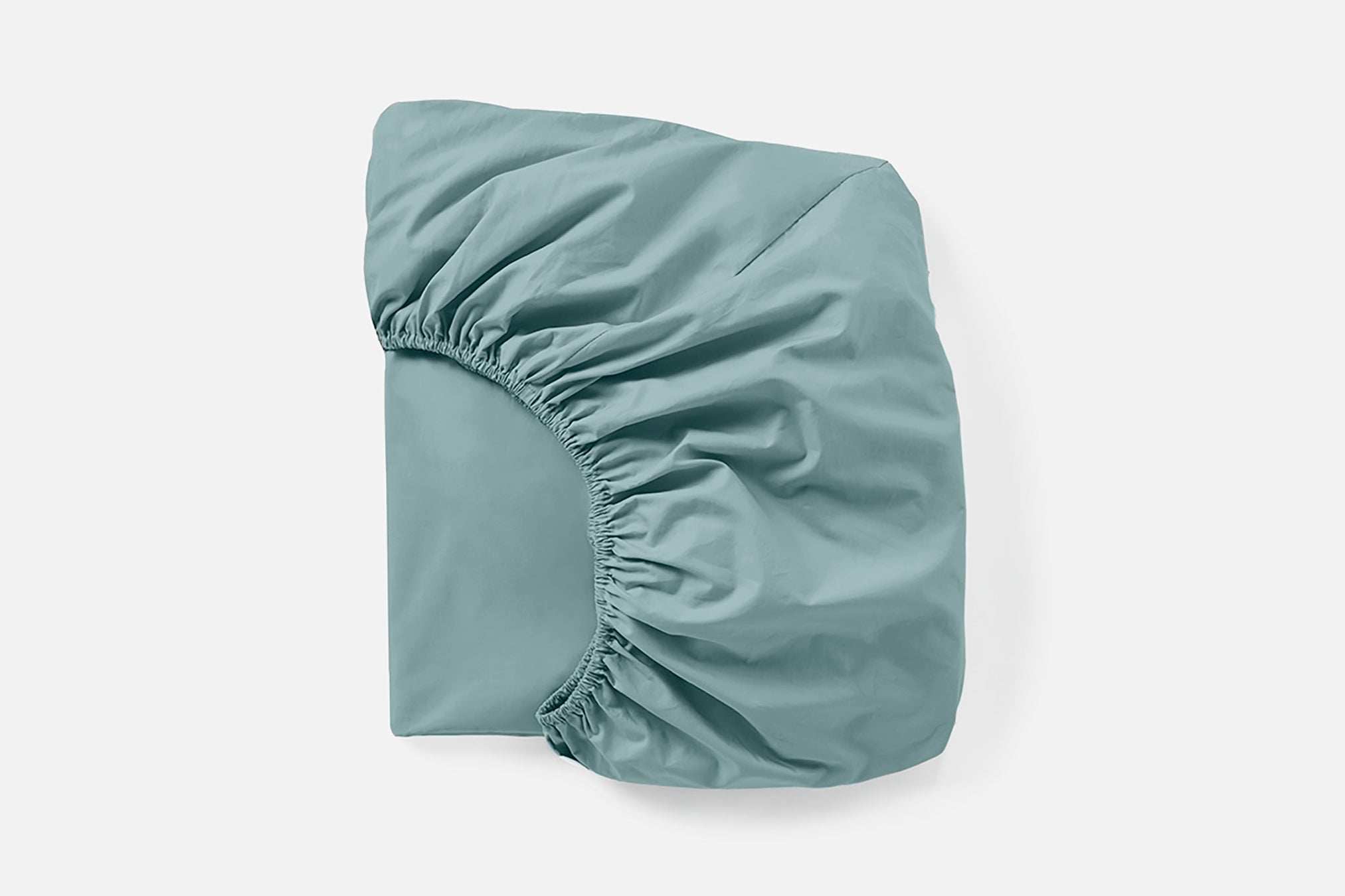 Coyuchi Refined Organic Percale Fitted Sheet in Pacific Blue – folded, displaying elastic in seam. #colour_pacific blue
