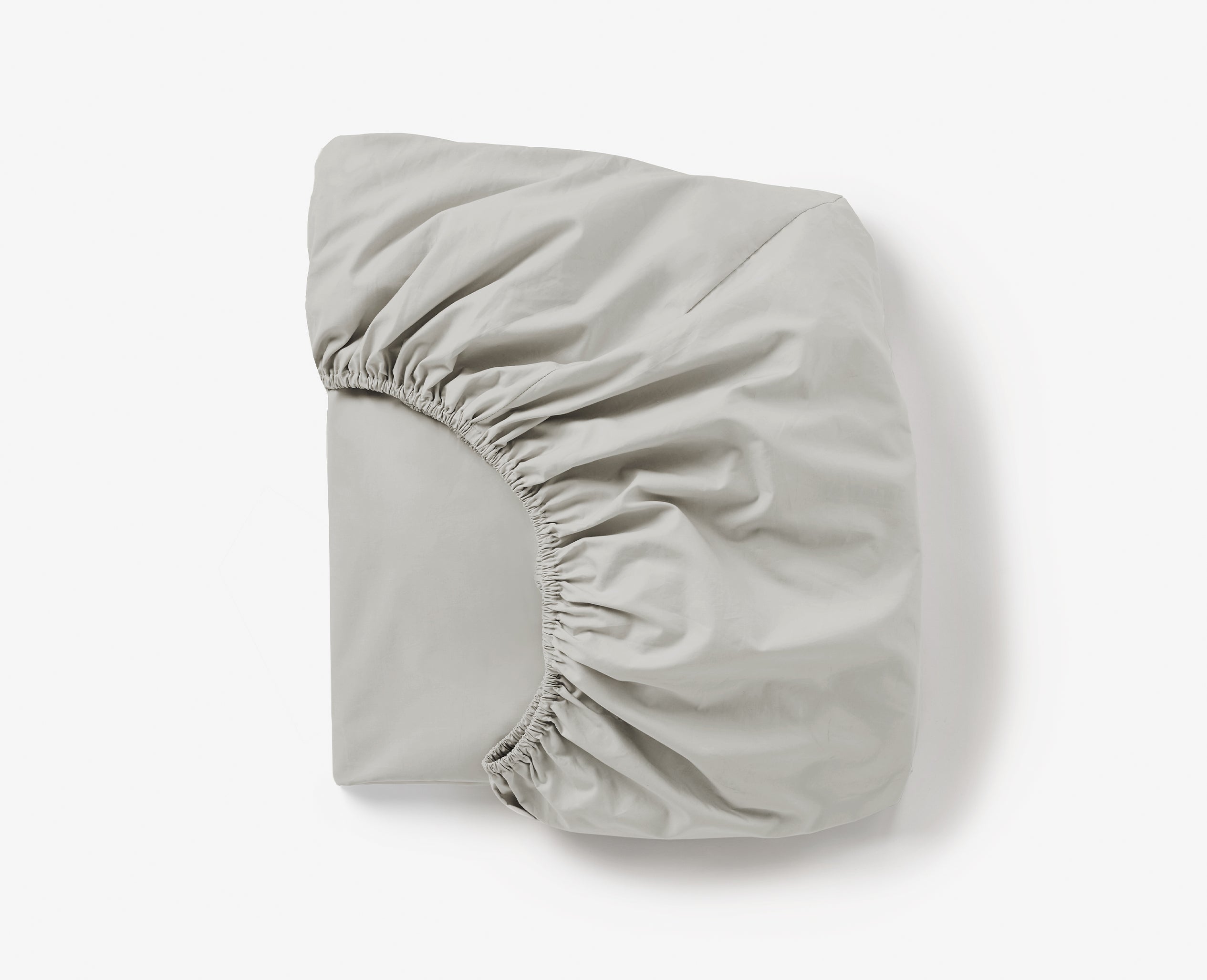 Coyuchi Refined Organic Percale Fitted Sheet in Seal – folded, displaying elastic in seam. #colour_seal