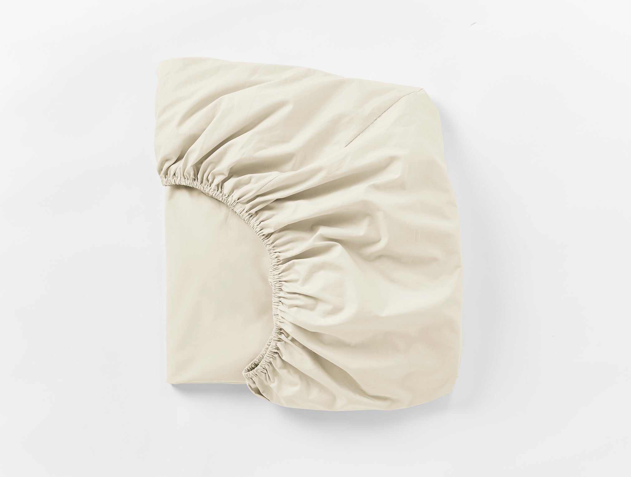 Coyuchi Refined Organic Percale Fitted Sheet in Undyed – folded, displaying elastic in seam. #colour_undyed
