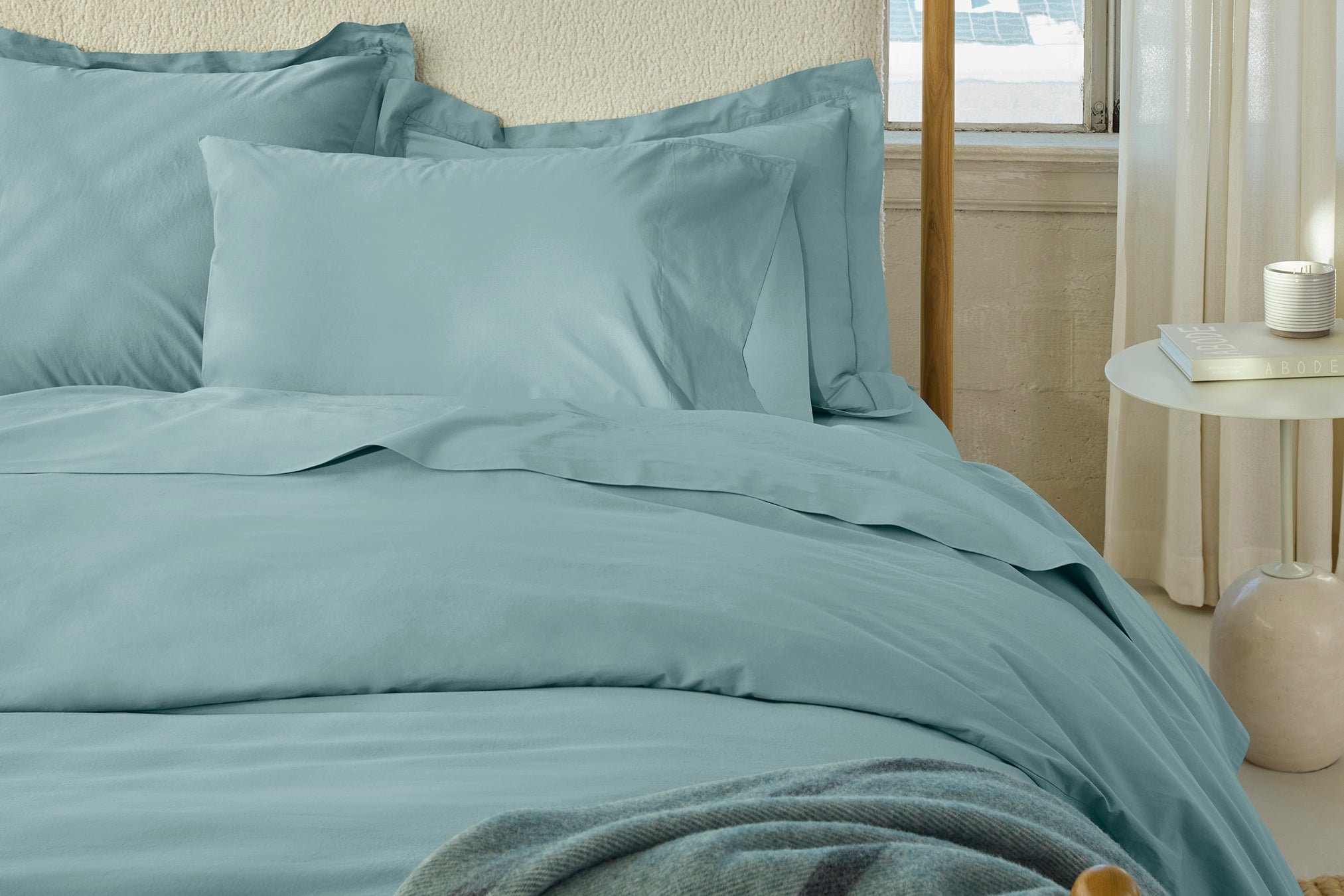 Coyuchi Refined Organic Cotton Percale Sheet Set in Pacific Blue – made bed highlighting the smoothness of the weave. #colour_pacific blue