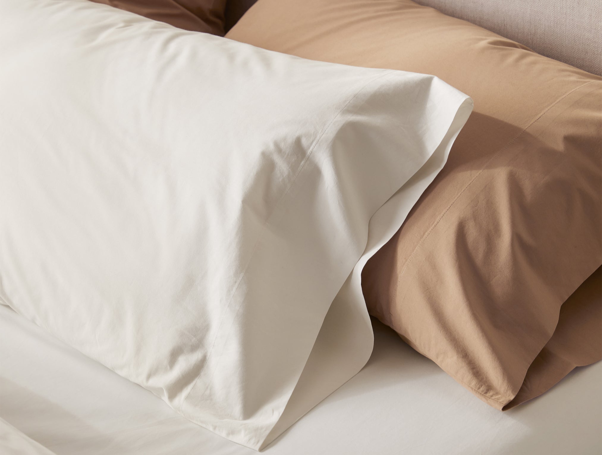Coyuchi Refined Organic Cotton Percale Sheet Set in Undyed - close-up on pillowcase highlighting smooth texture. #colour_undyed