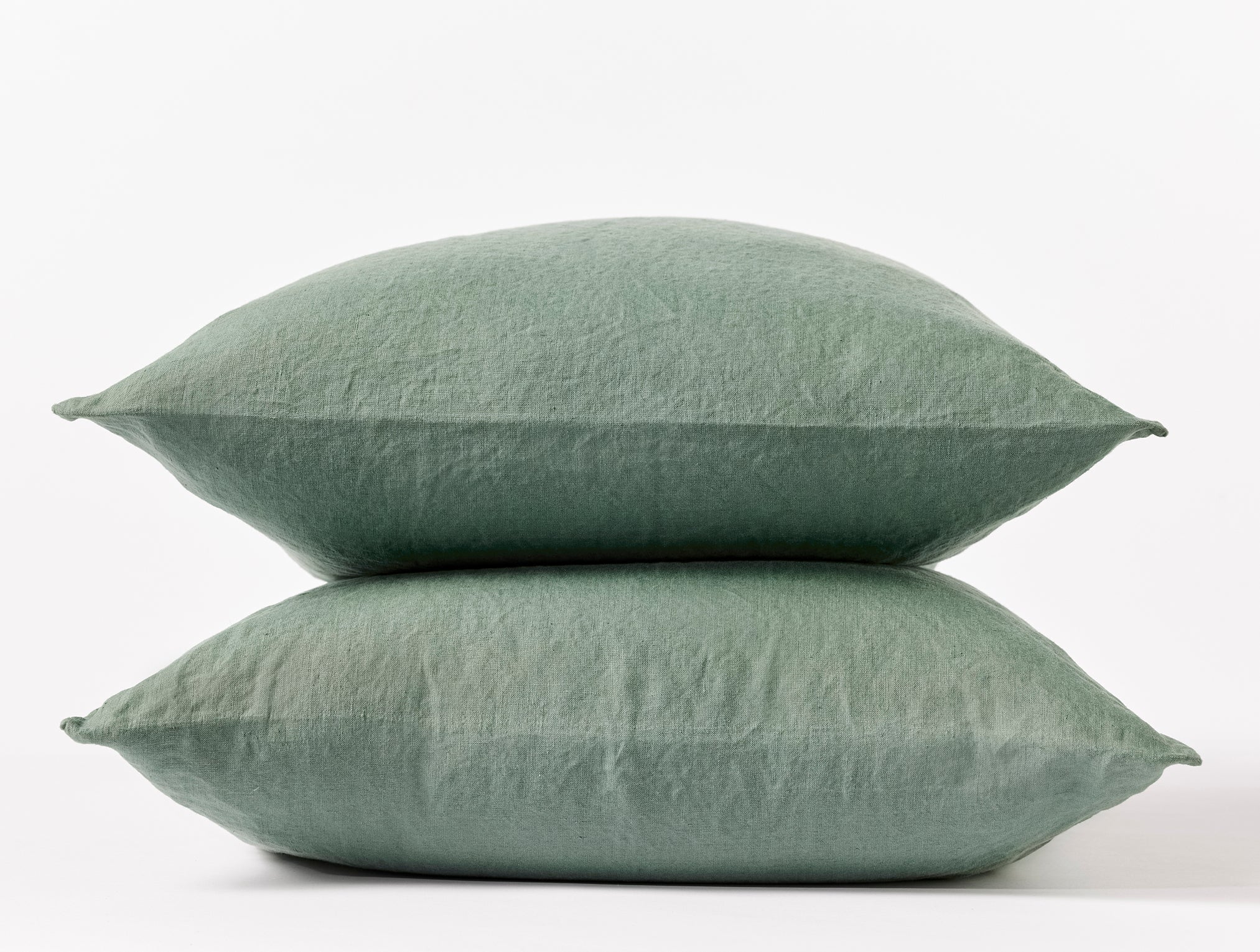 Coyuchi Organic Relaxed Linen Pillowcases in Juniper – two stacked pillows, showing pillowcase fit and linen texture. #colour_juniper