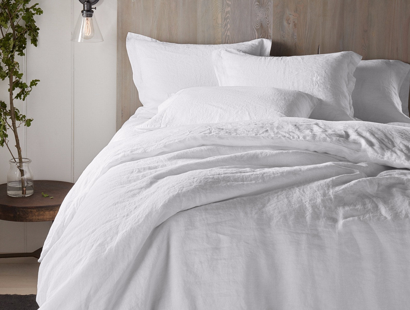 Coyuchi Organic Relaxed Linen Sheet Set in Alpine White – styled on made bed, showing vibrant white. #colour_alpine white
