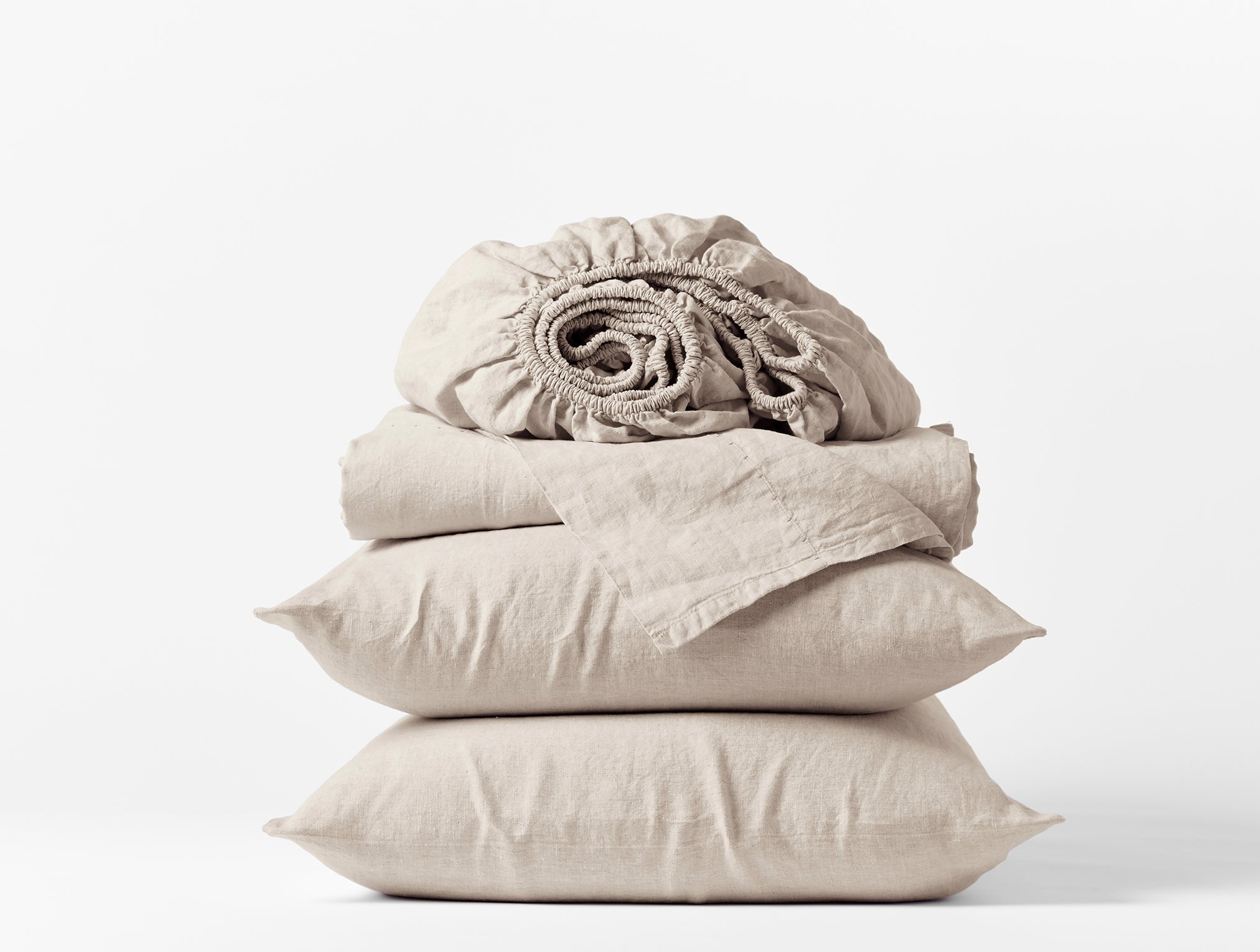Coyuchi Organic Relaxed Linen Sheet Set in Natural Chambray – stacked view with pillows and folded sheets. #colour_natural chambray
