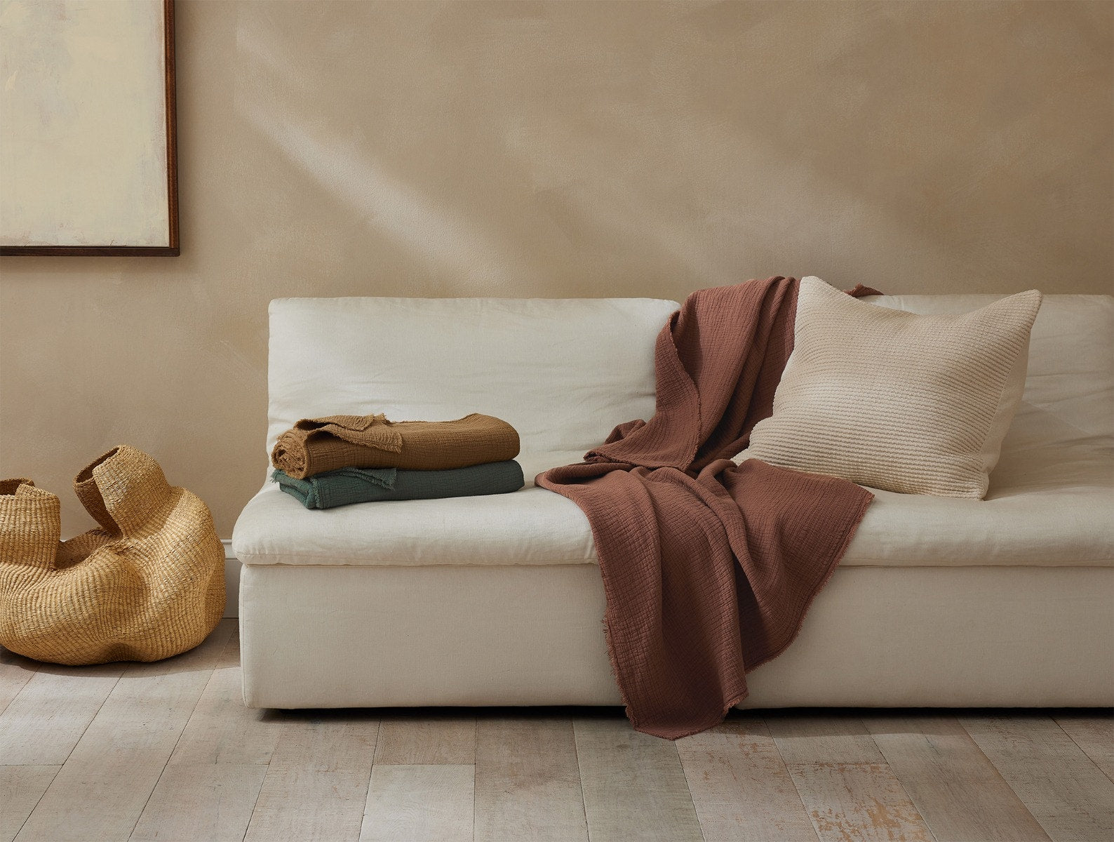 Coyuchi Topanga Organic Cotton Matelasse Throw - staged redwood throw draped over couch #colour_redwood