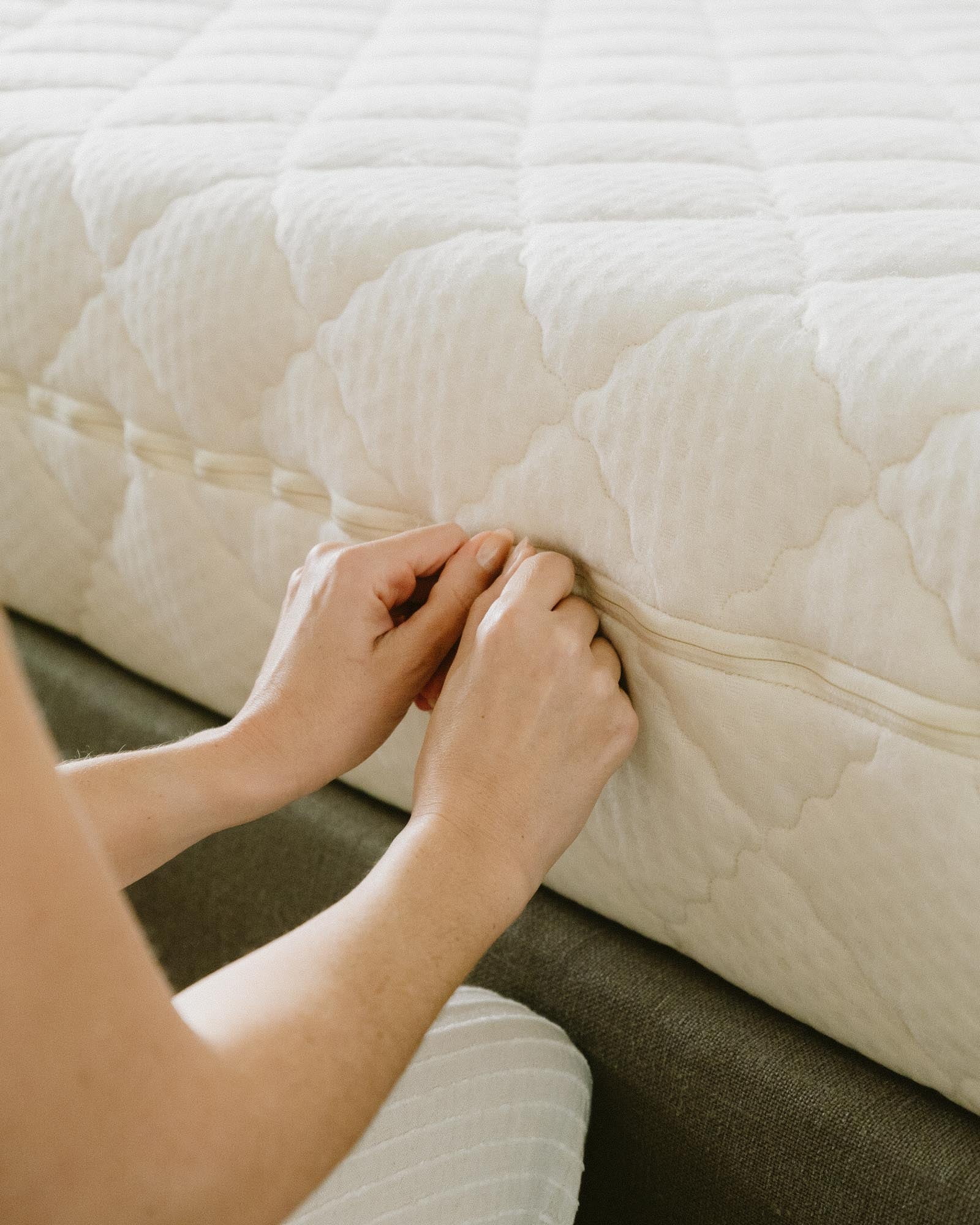 Kakun Nine Organic Latex Mattress - side view with model holding zippers