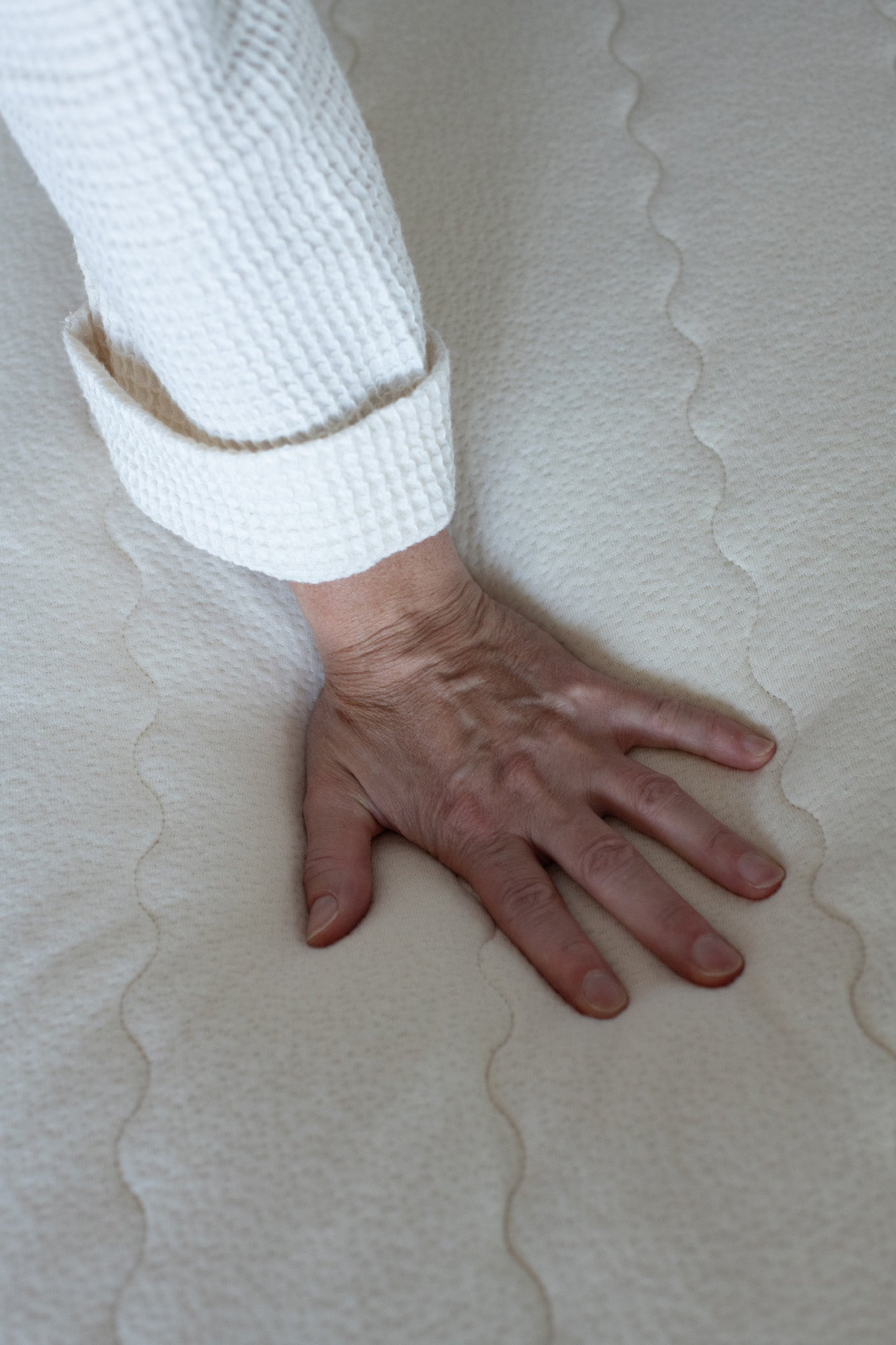Kakun Organic Latex Mattress - models hand pushing on mattress